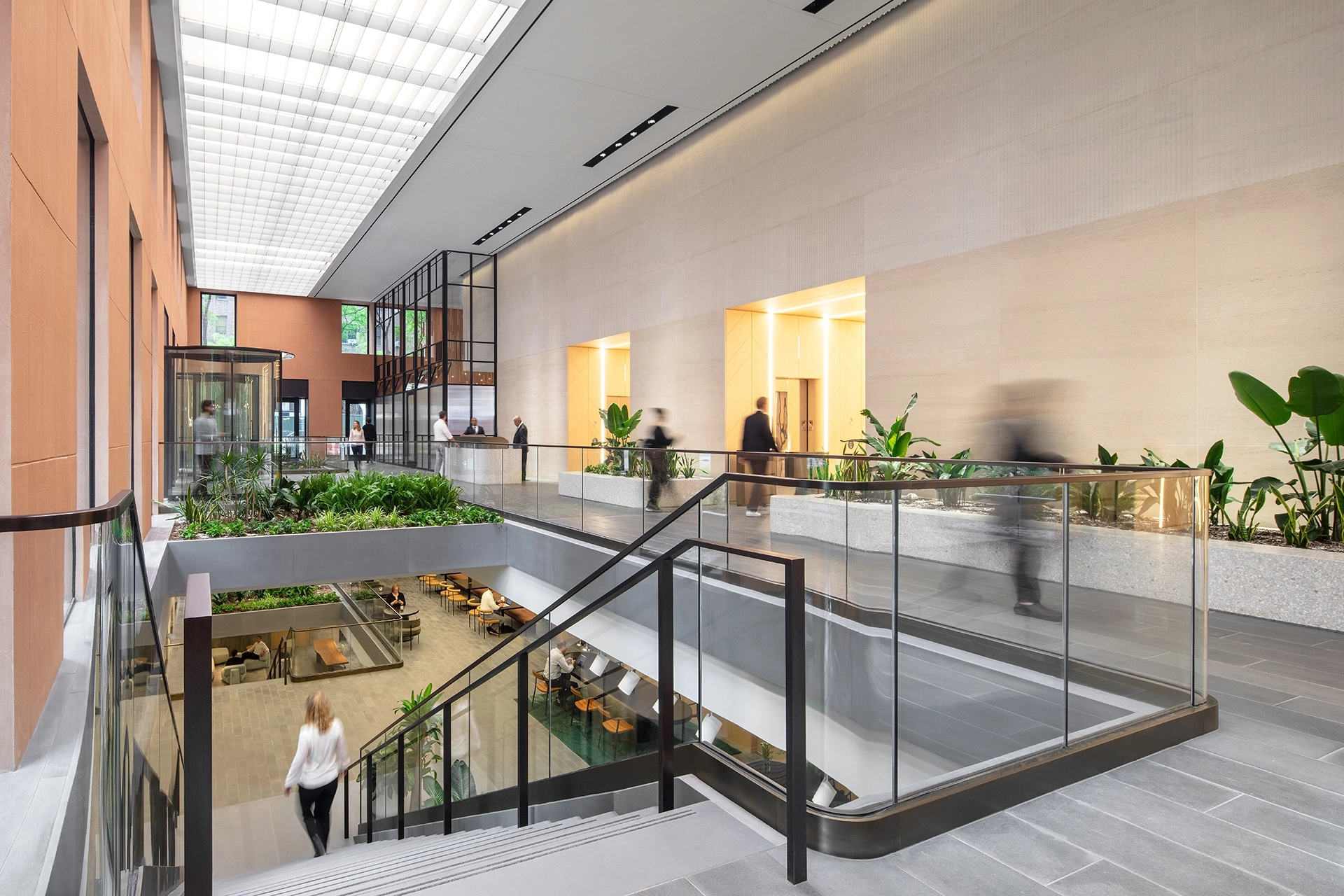 A coworking office building in New York City featuring a glass atrium and stairs.