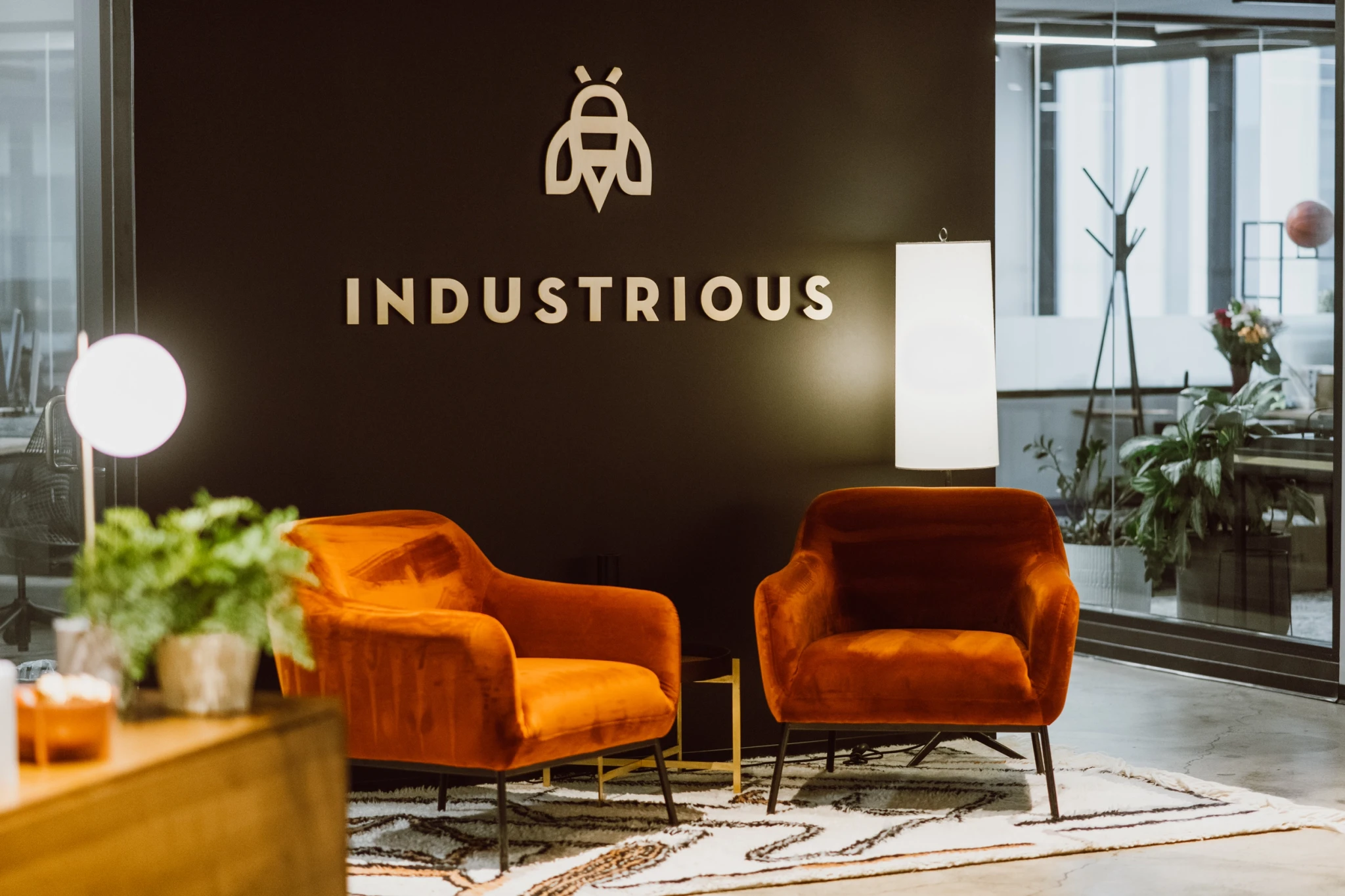 Industrious logo with soft orange chairs in reception area