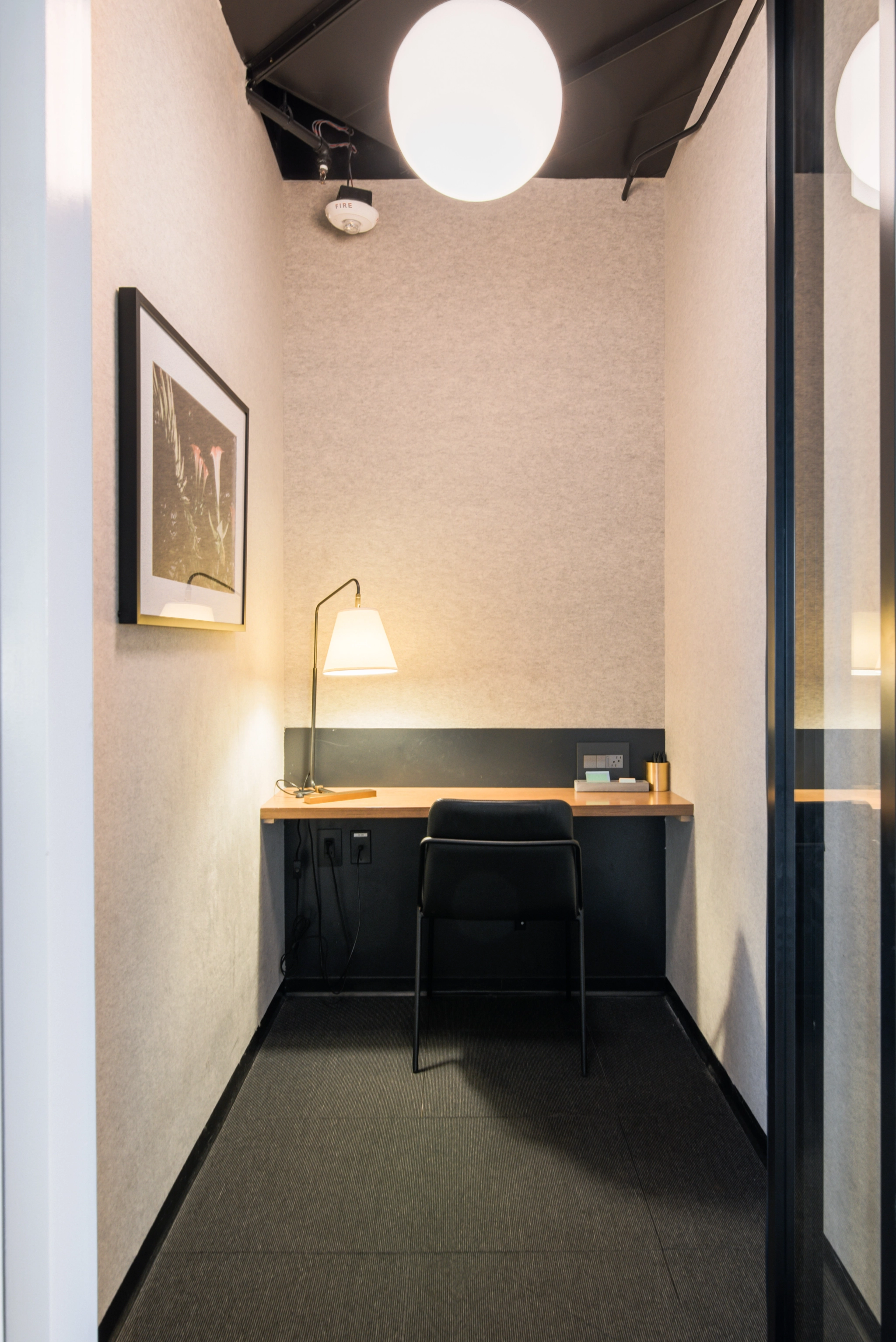 A private phone room with chair and wood desktop