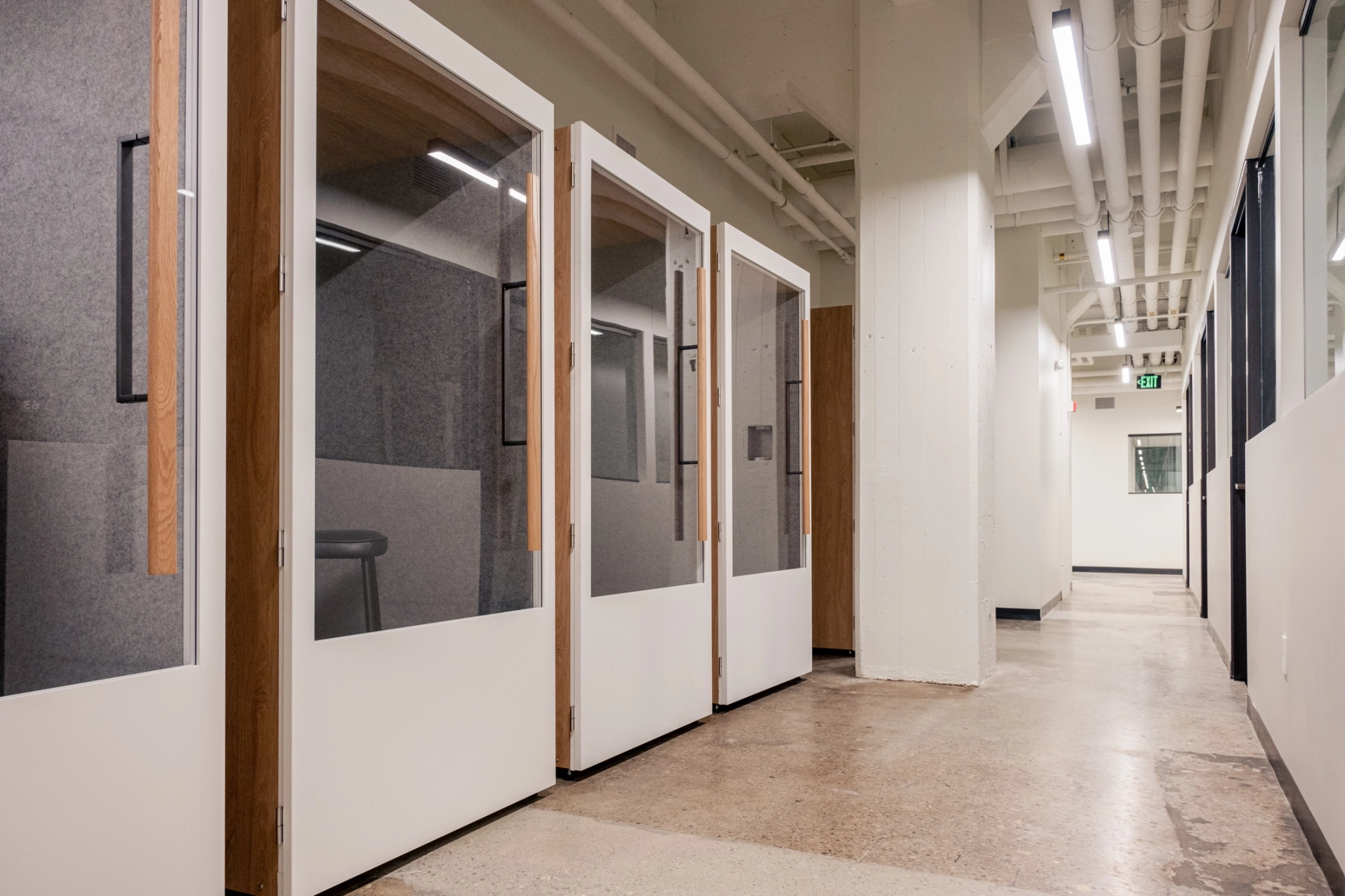 a coworking office with glass doors in the hallway.