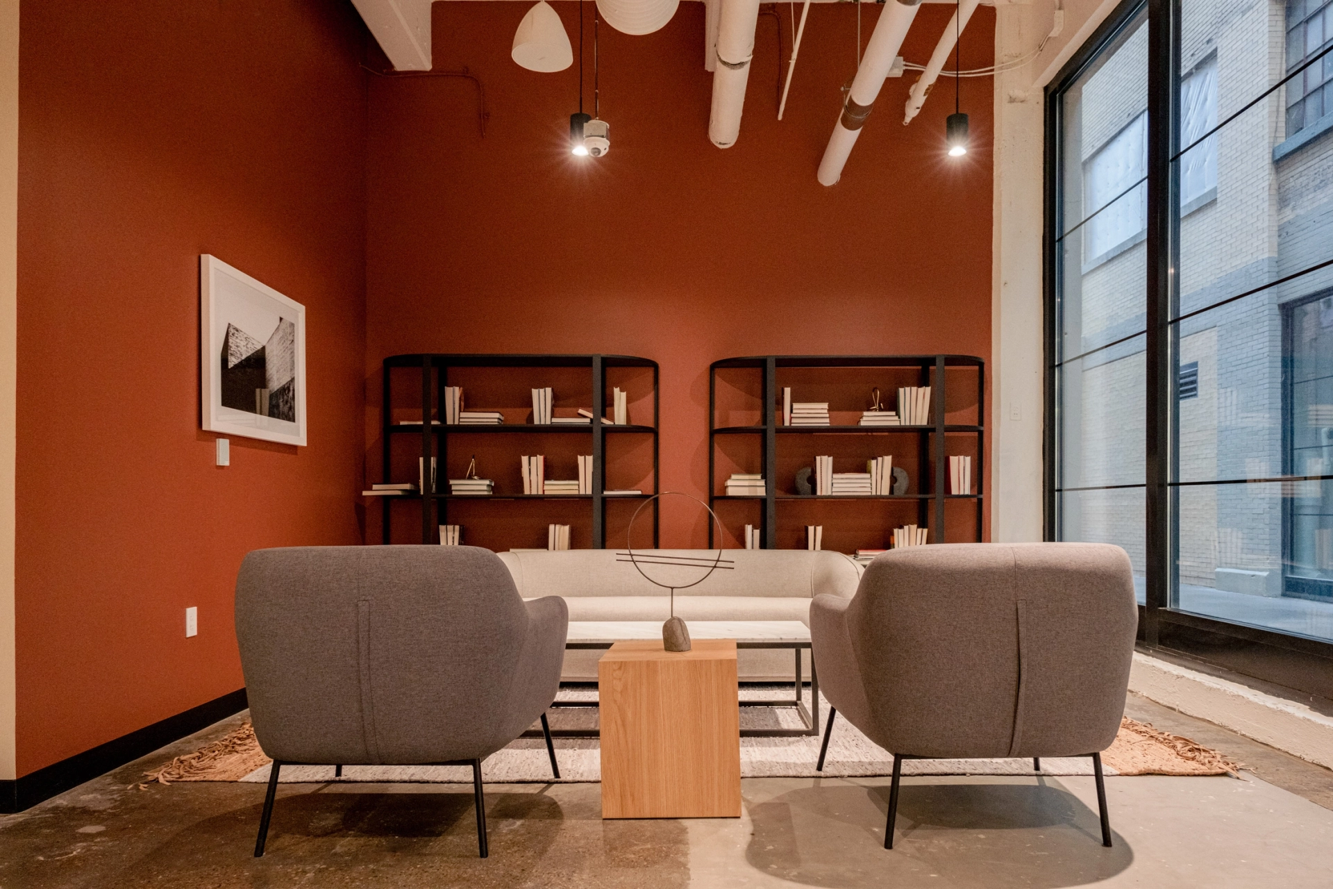 un espace de coworking avec deux chaises et une bibliothèque.