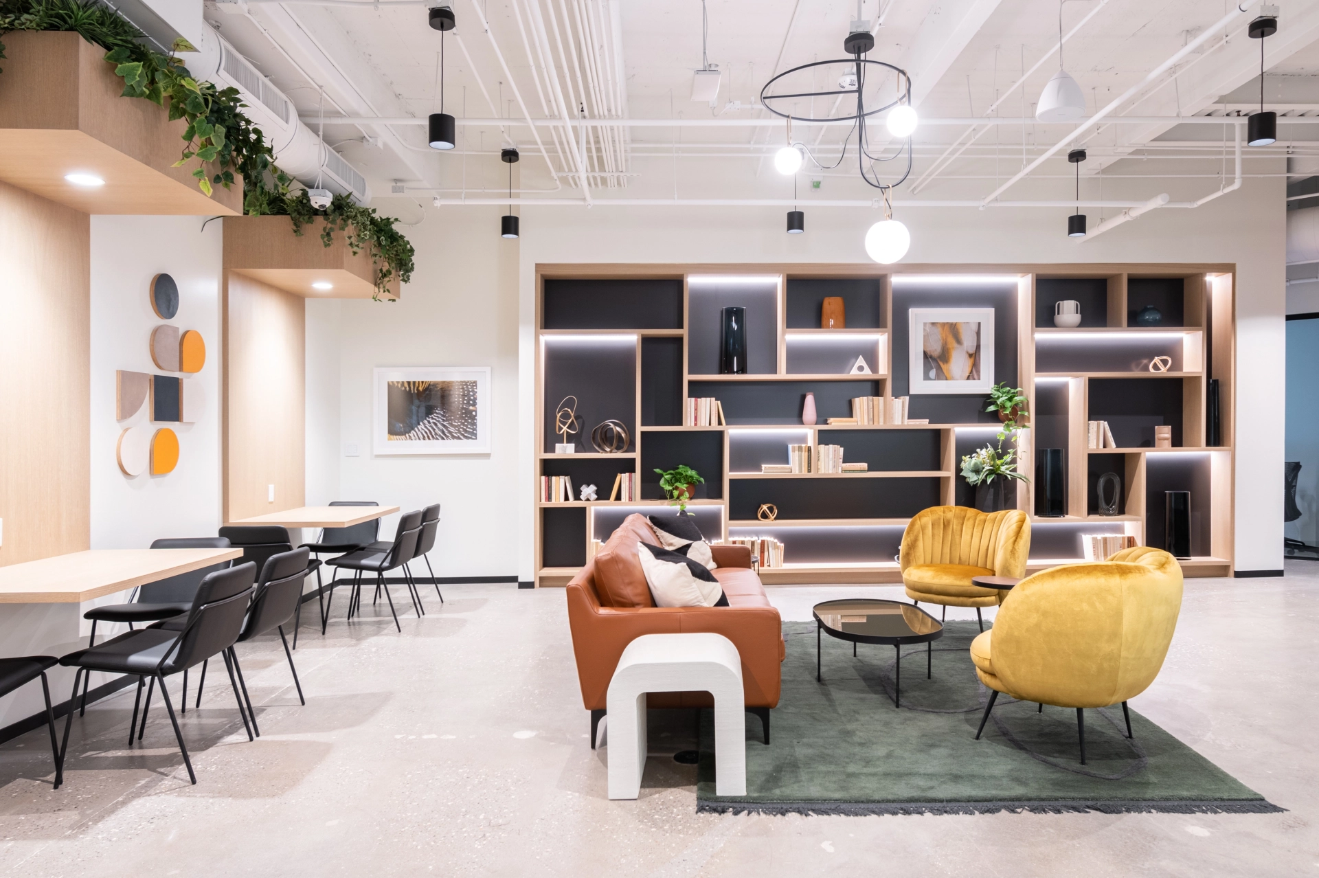 Un bureau de coworking moderne avec des chaises jaunes et une plante au mur.