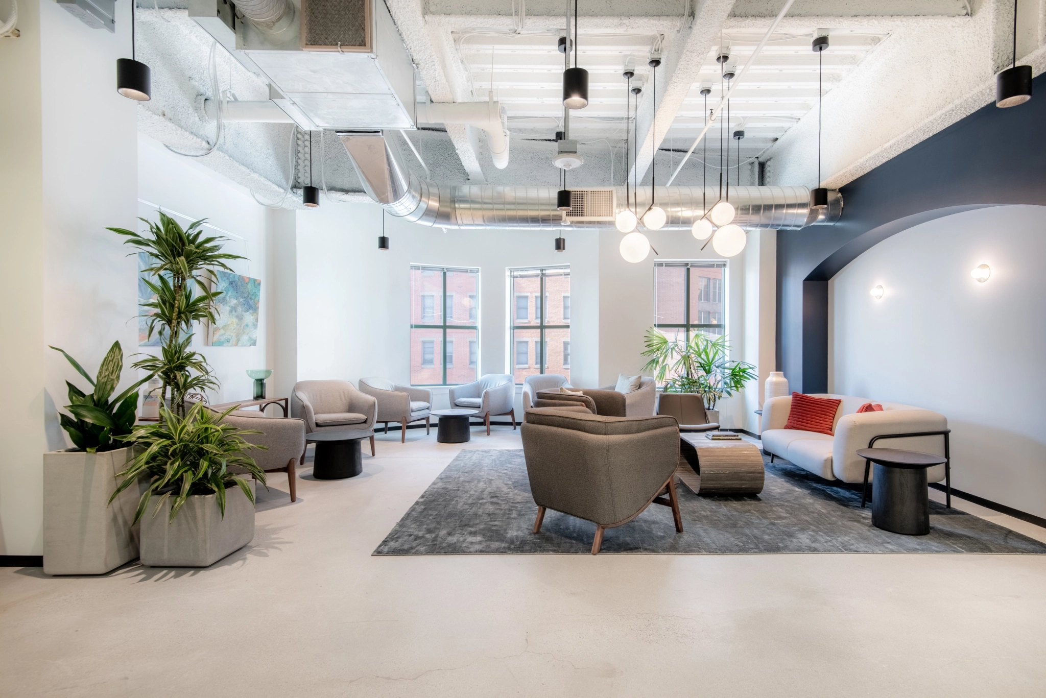 Un bureau de coworking moderne avec des canapés confortables, des chaises et des plantes.