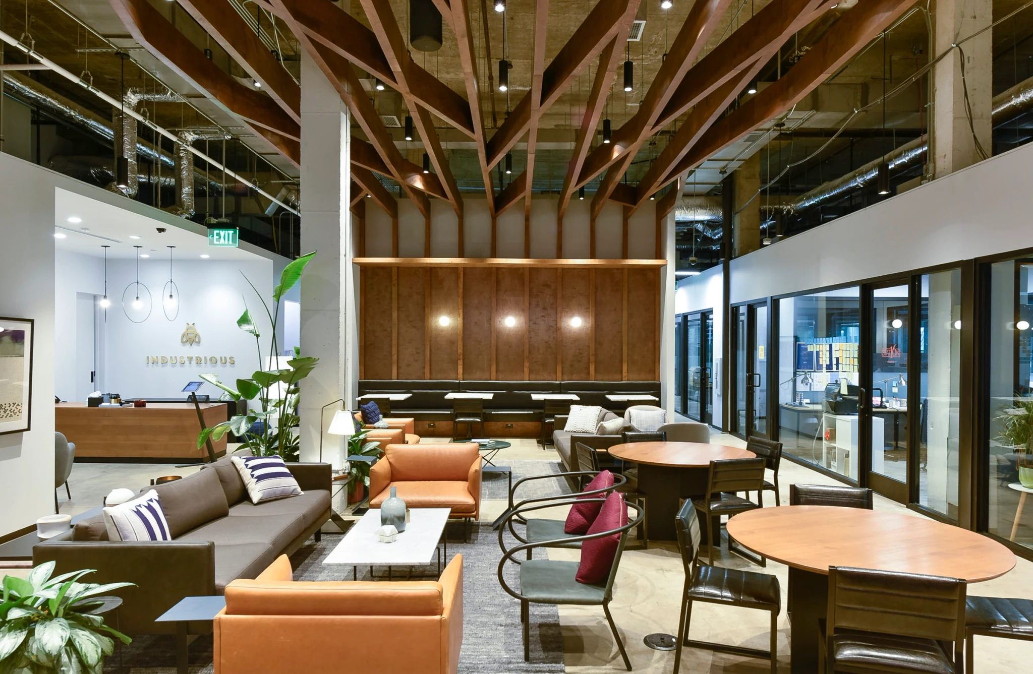 The modern office lobby provides a collaborative workspace with comfortable couches and tables.
