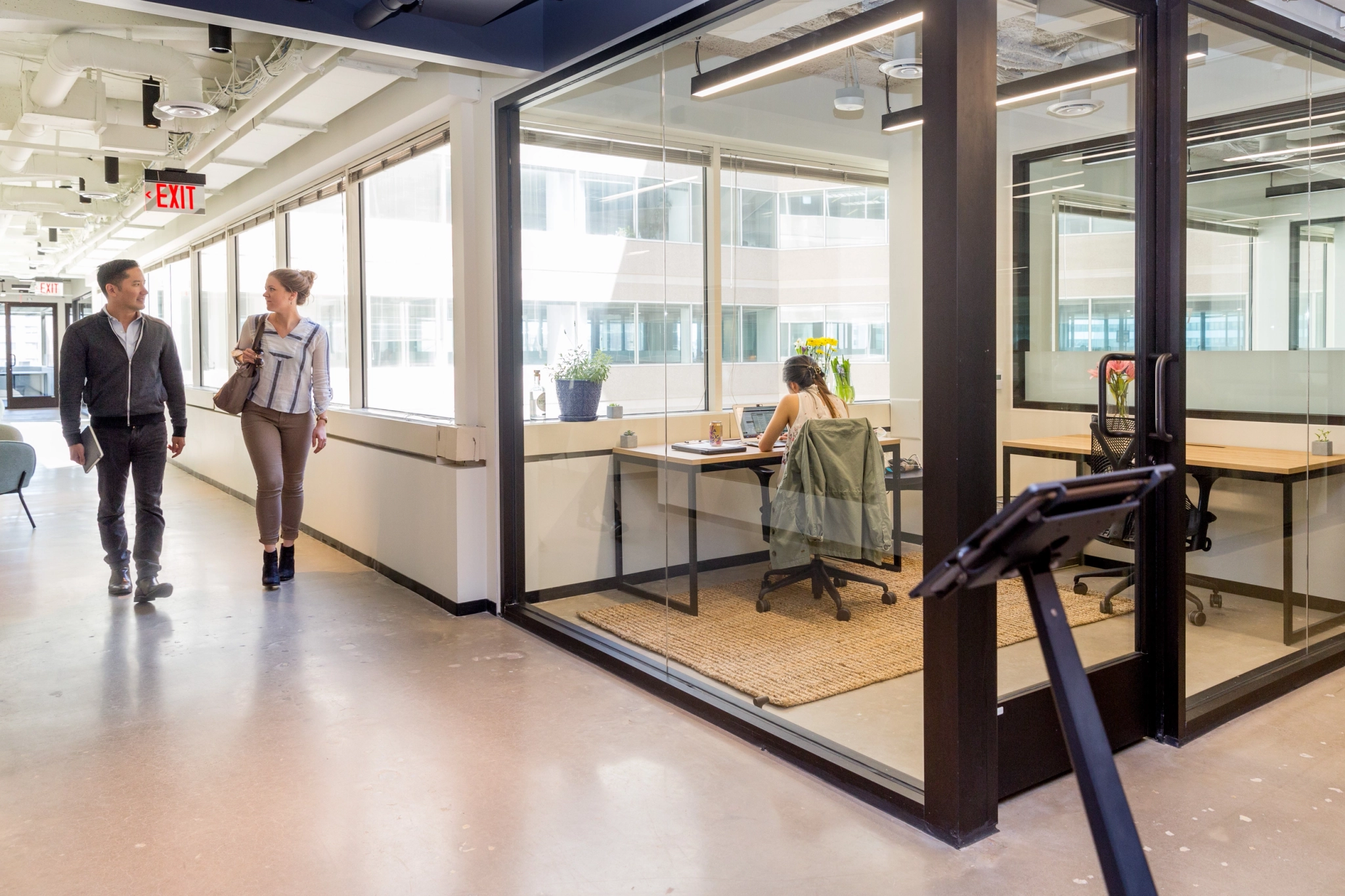 Two coworkers walking through a glass-walled office in Washington.