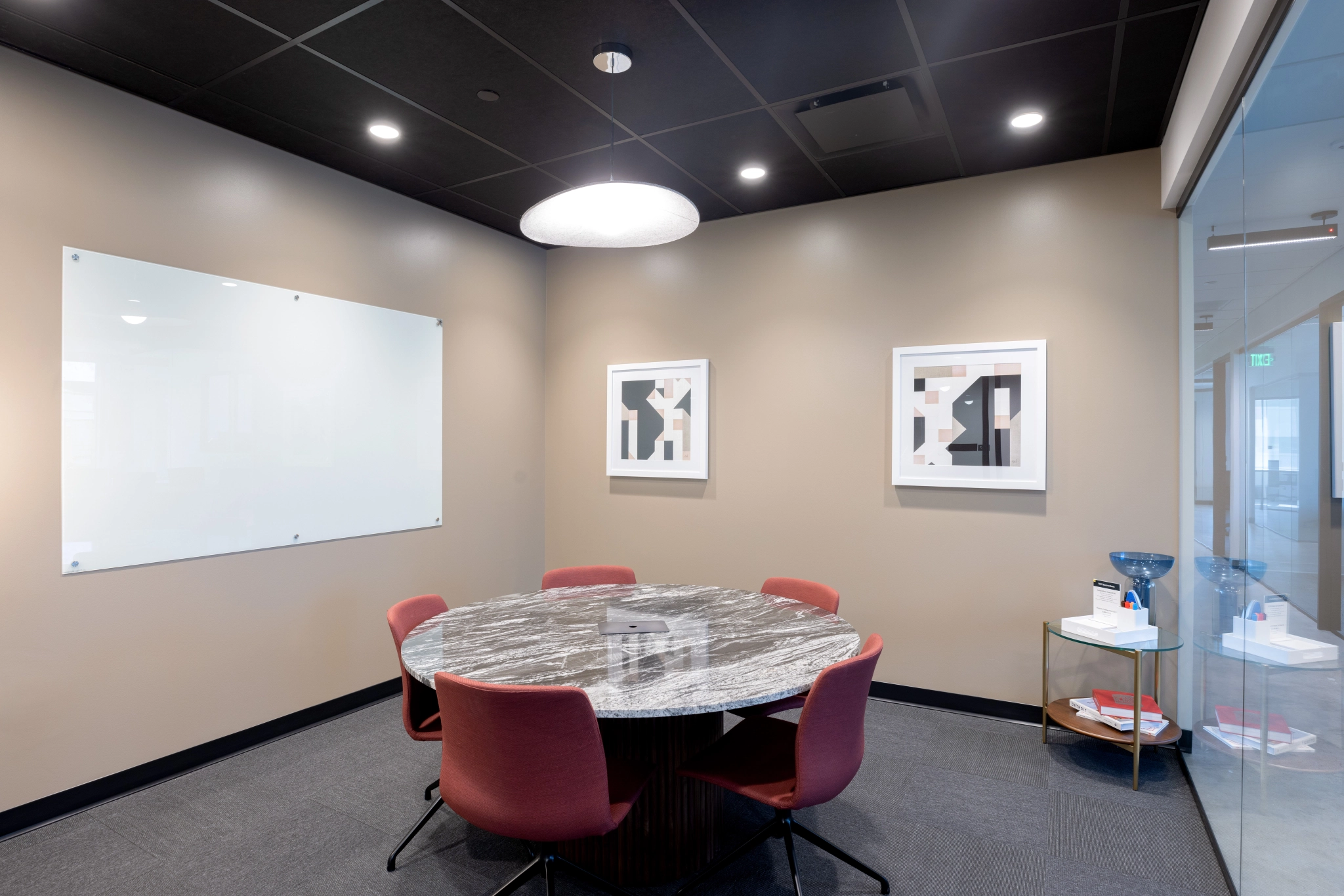 A meeting room with a round table for collaborative workspace in an office setting.