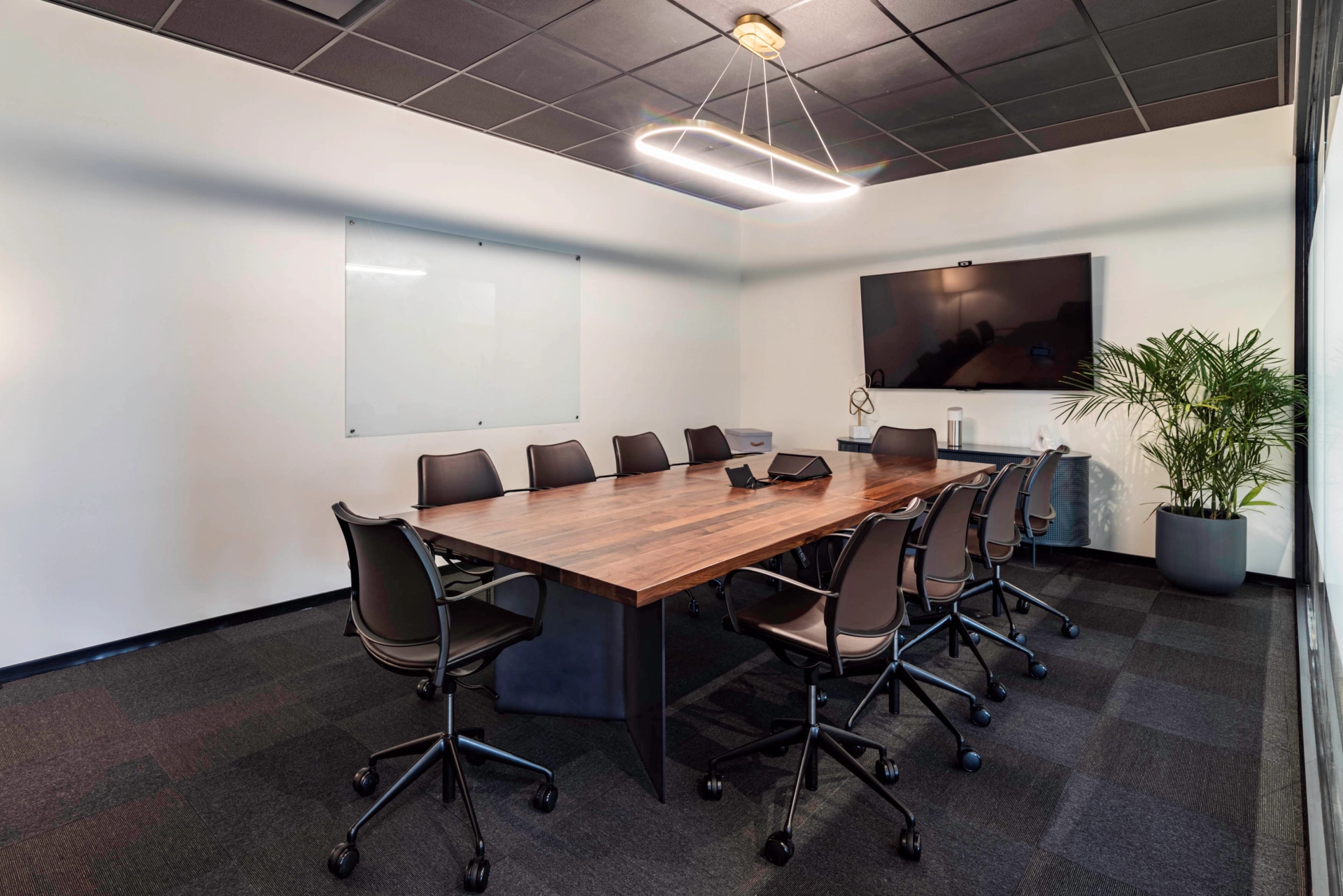 Une salle de conférence en bois avec une table et des chaises pour les réunions de bureau.
