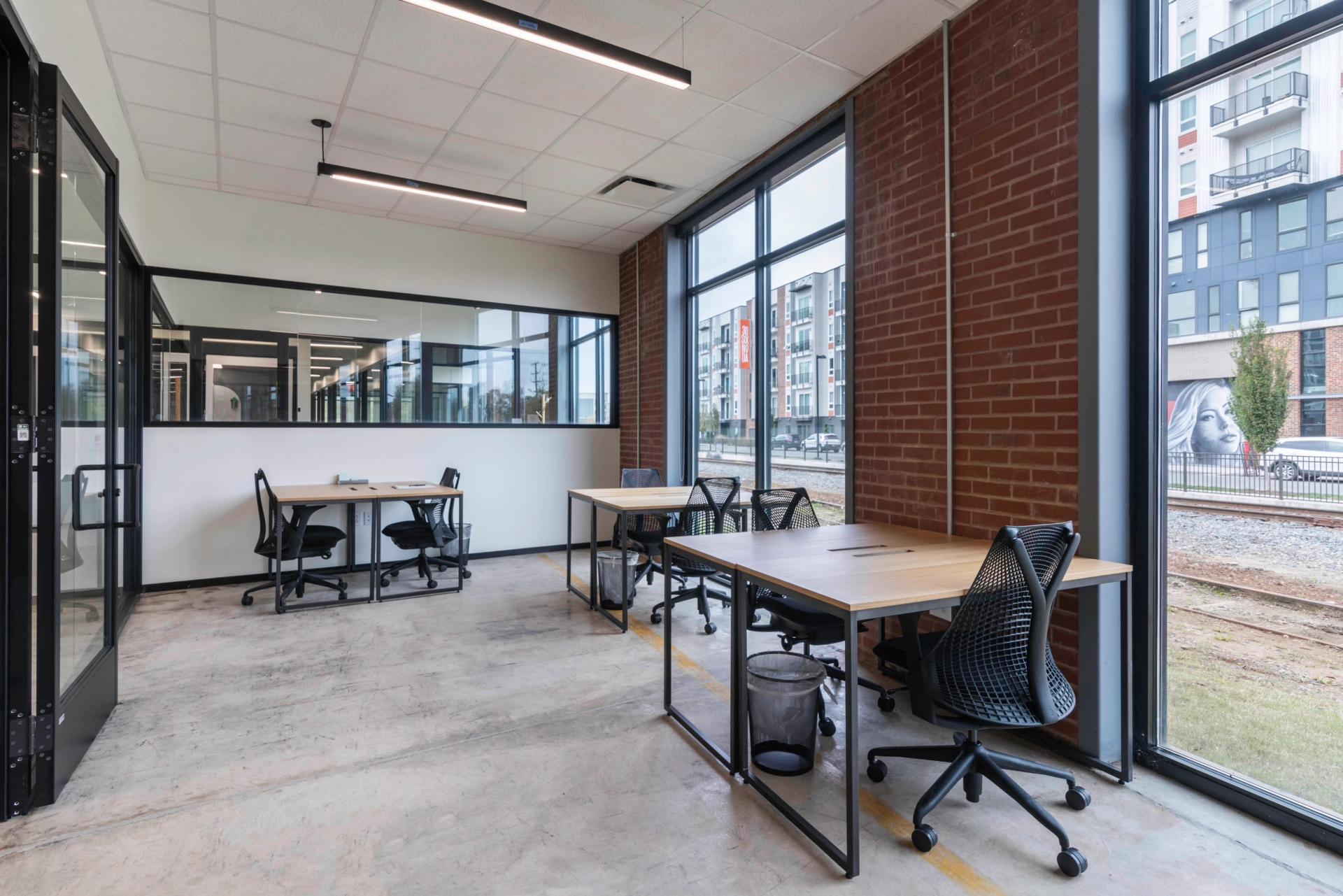 An open coworking space with large windows and a desk.