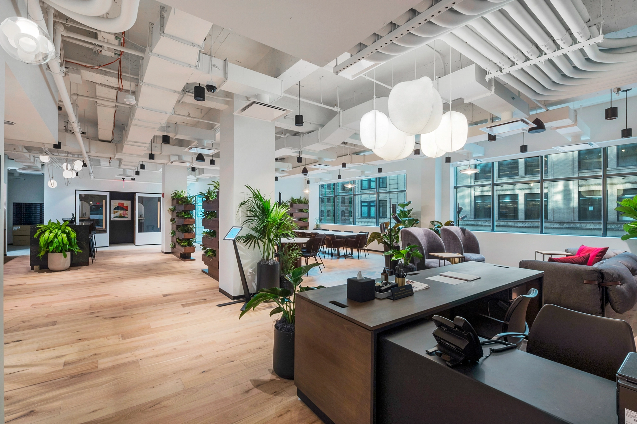 A modern workspace in New York featuring wooden floors and plants.