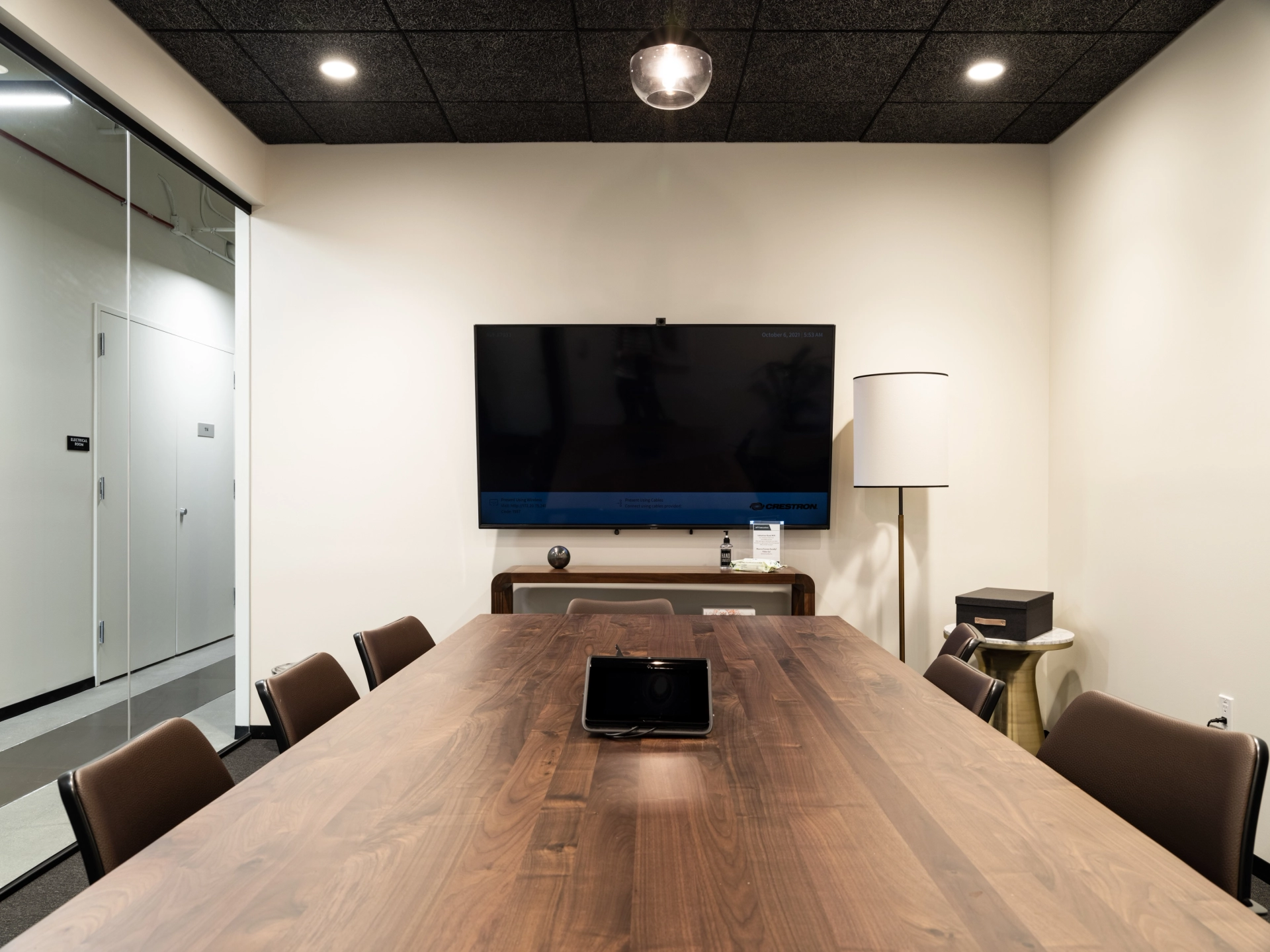 Une salle de réunion de coworking équipée d'une table en bois et d'une télévision.