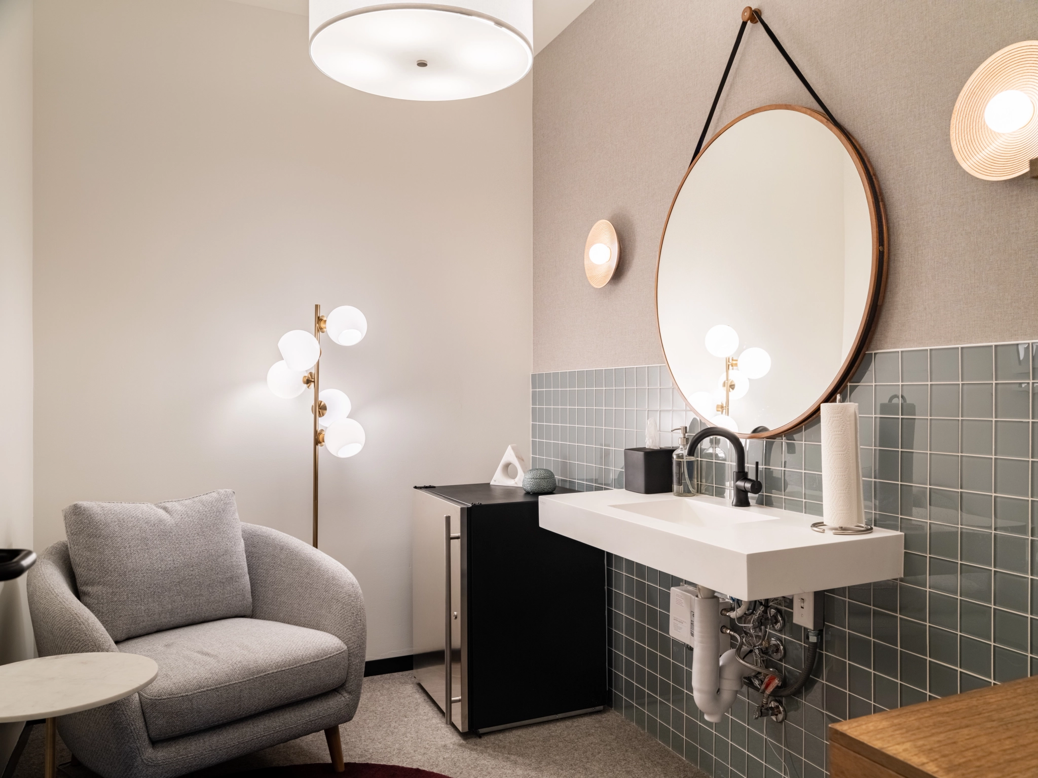 A Concord office bathroom with a sink, mirror, and a chair.