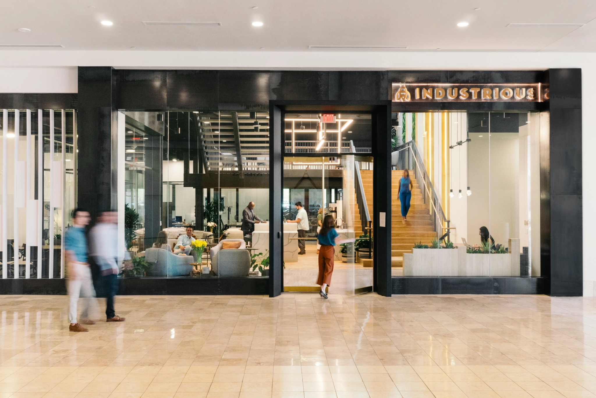 A Scottsdale workspace lobby with people walking in front of it.