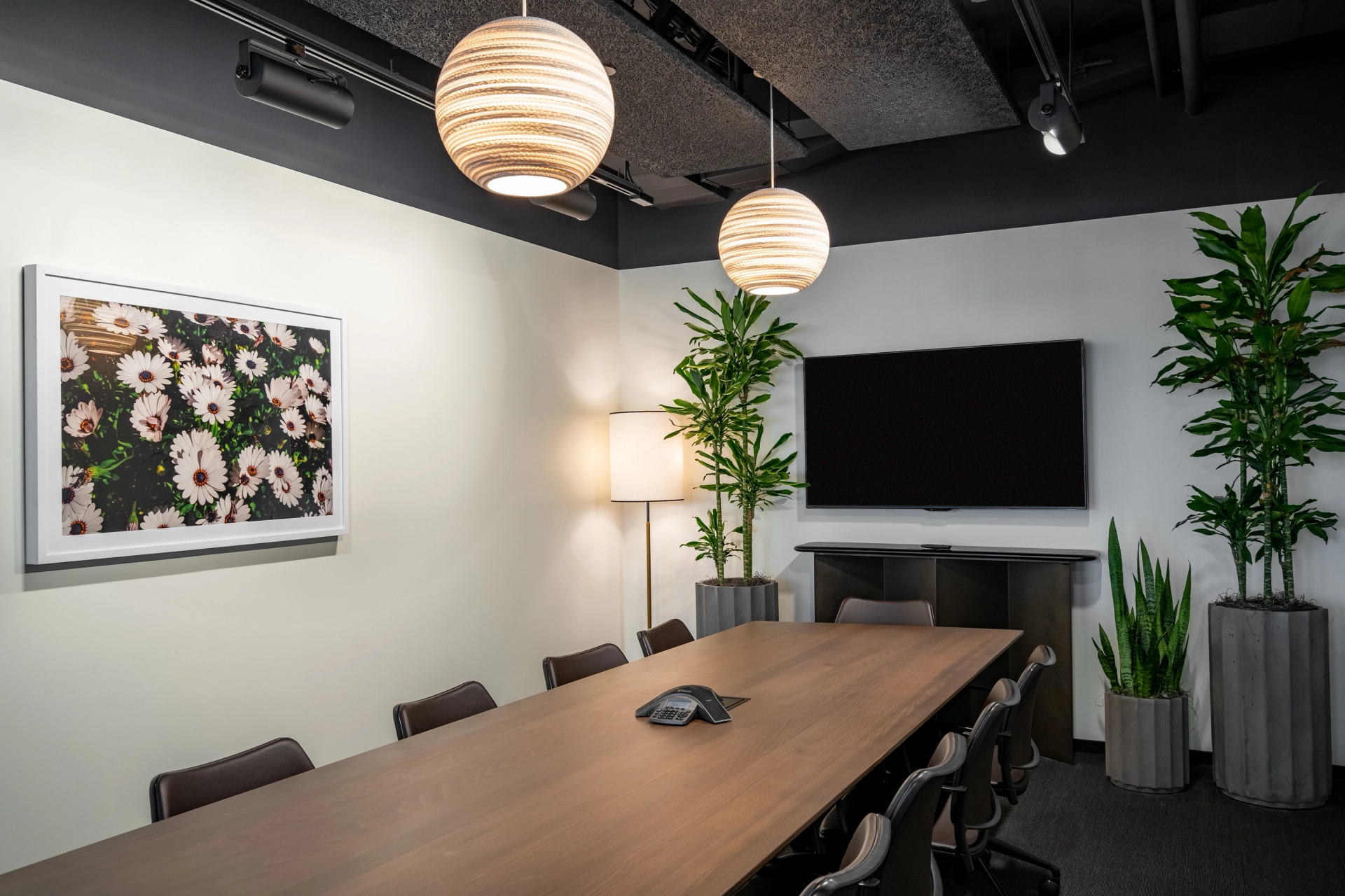 Un espace de coworking de bureau McLean comprenant une salle de conférence ornée d'une grande table et de plantes.