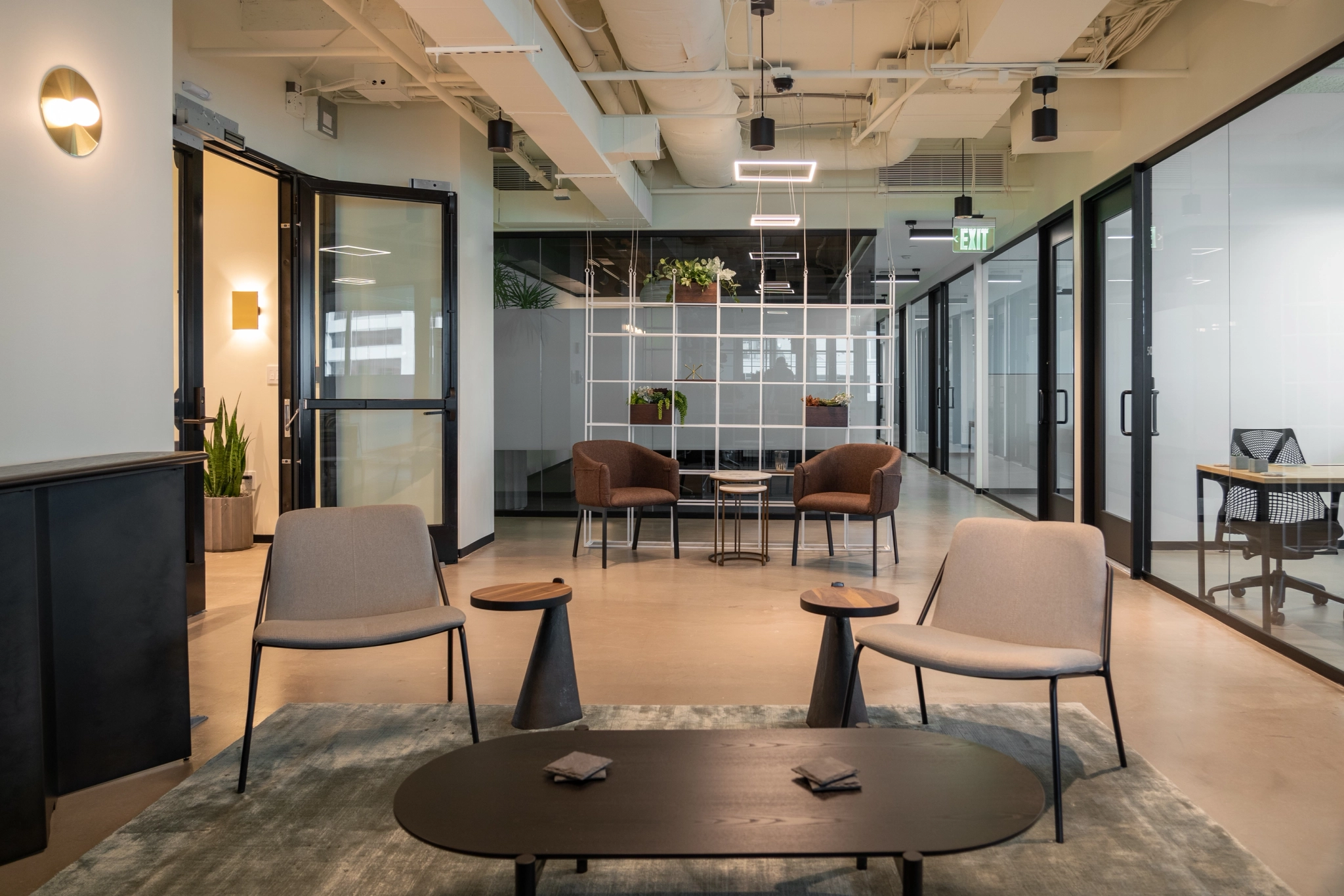 Un espace de coworking moderne équipé de chaises, de tables et de portes vitrées.