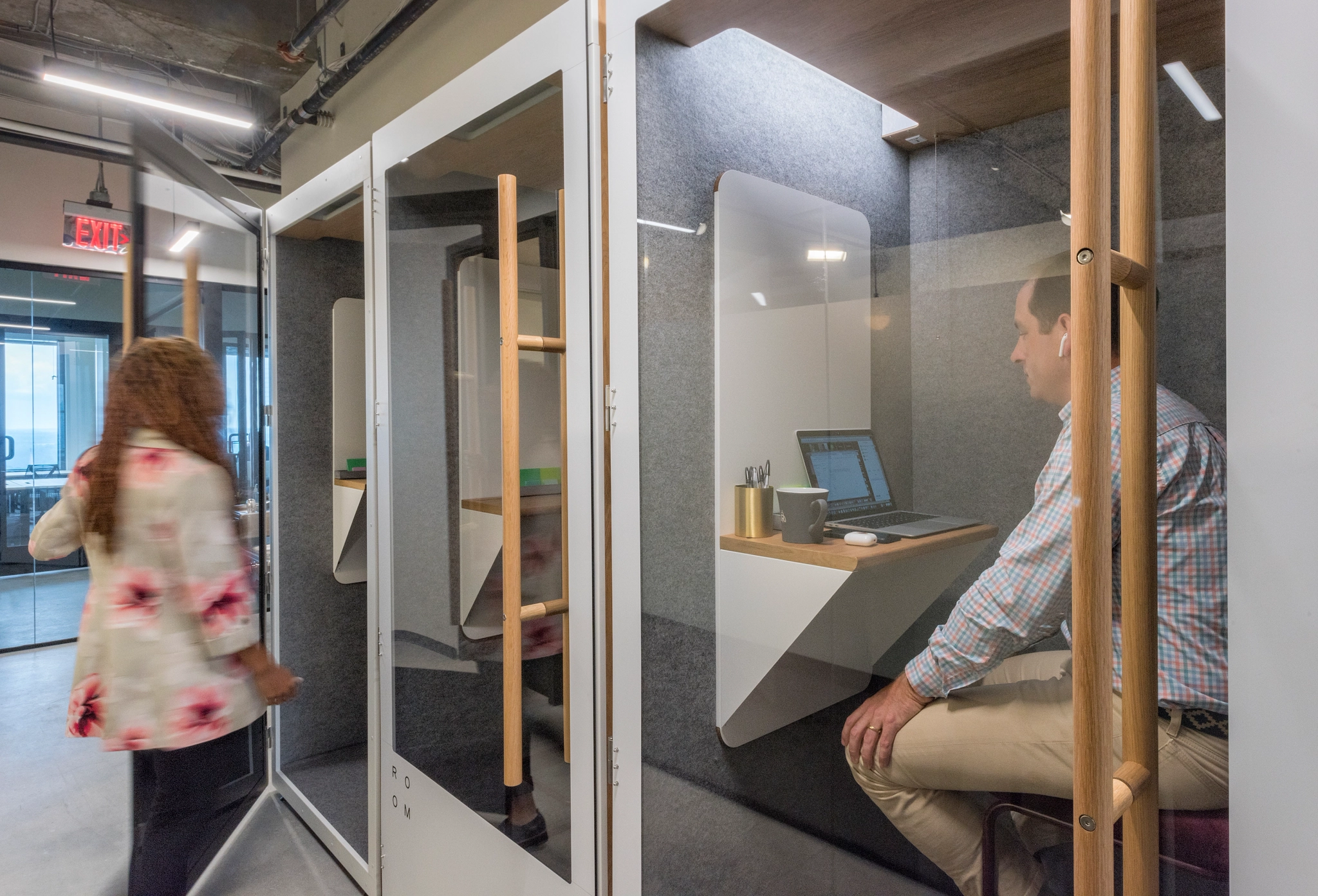 A man and woman are having a meeting in a glass workspace.