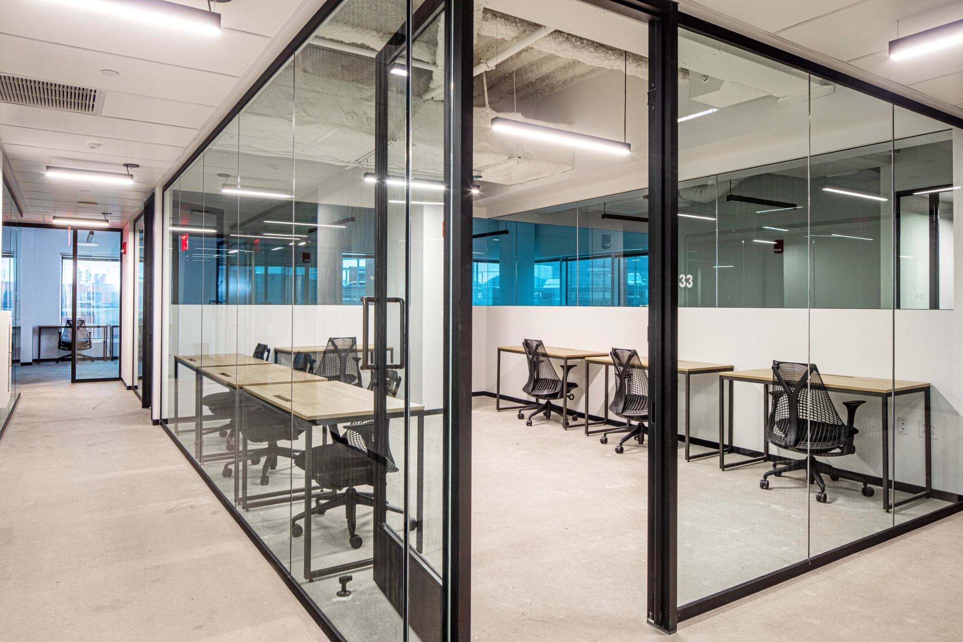 A Pittsburgh workspace featuring glass walls, desks, and chairs.