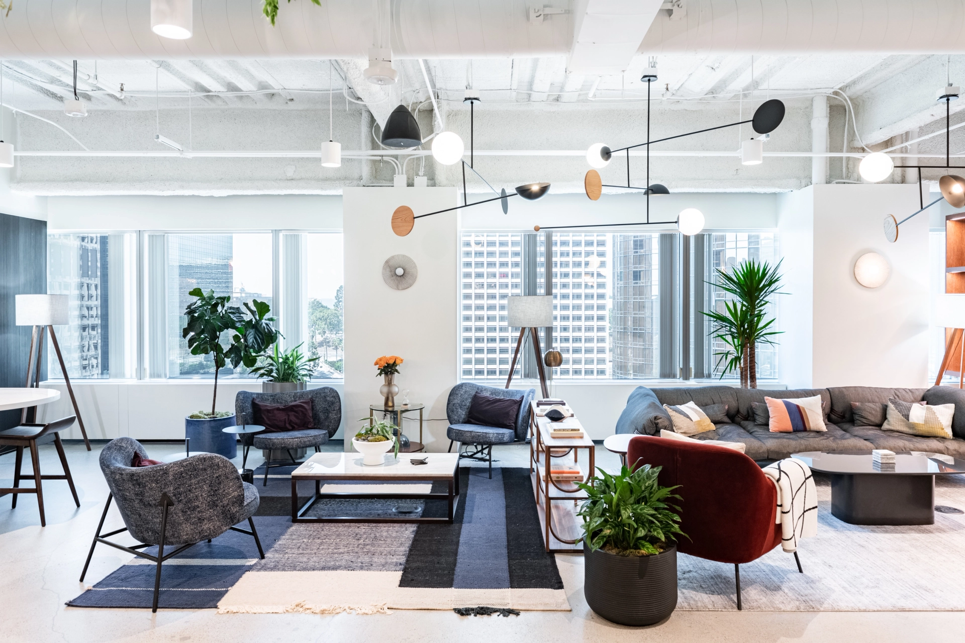 un bureau de coworking moderne avec beaucoup de mobilier et de plantes.