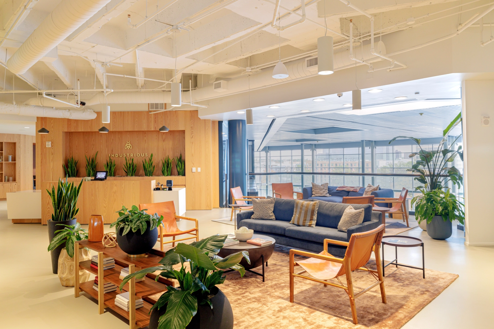 A spacious coworking area with comfortable couches and vibrant plants.