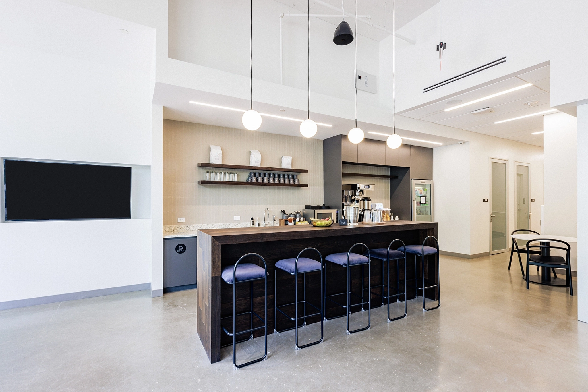 A modern office workspace with a bar and stools.