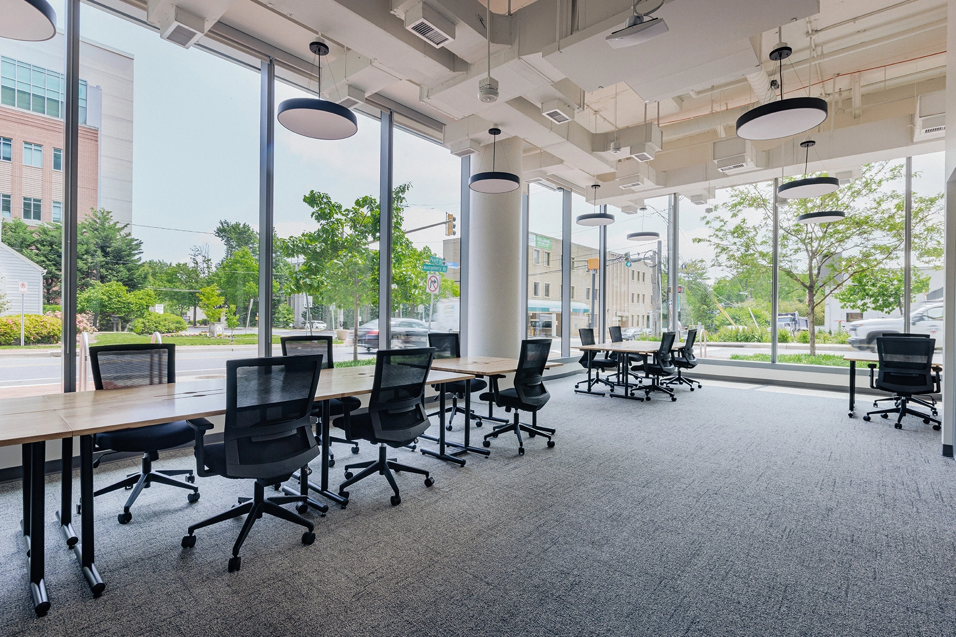a coworking meeting room with large windows and chairs.