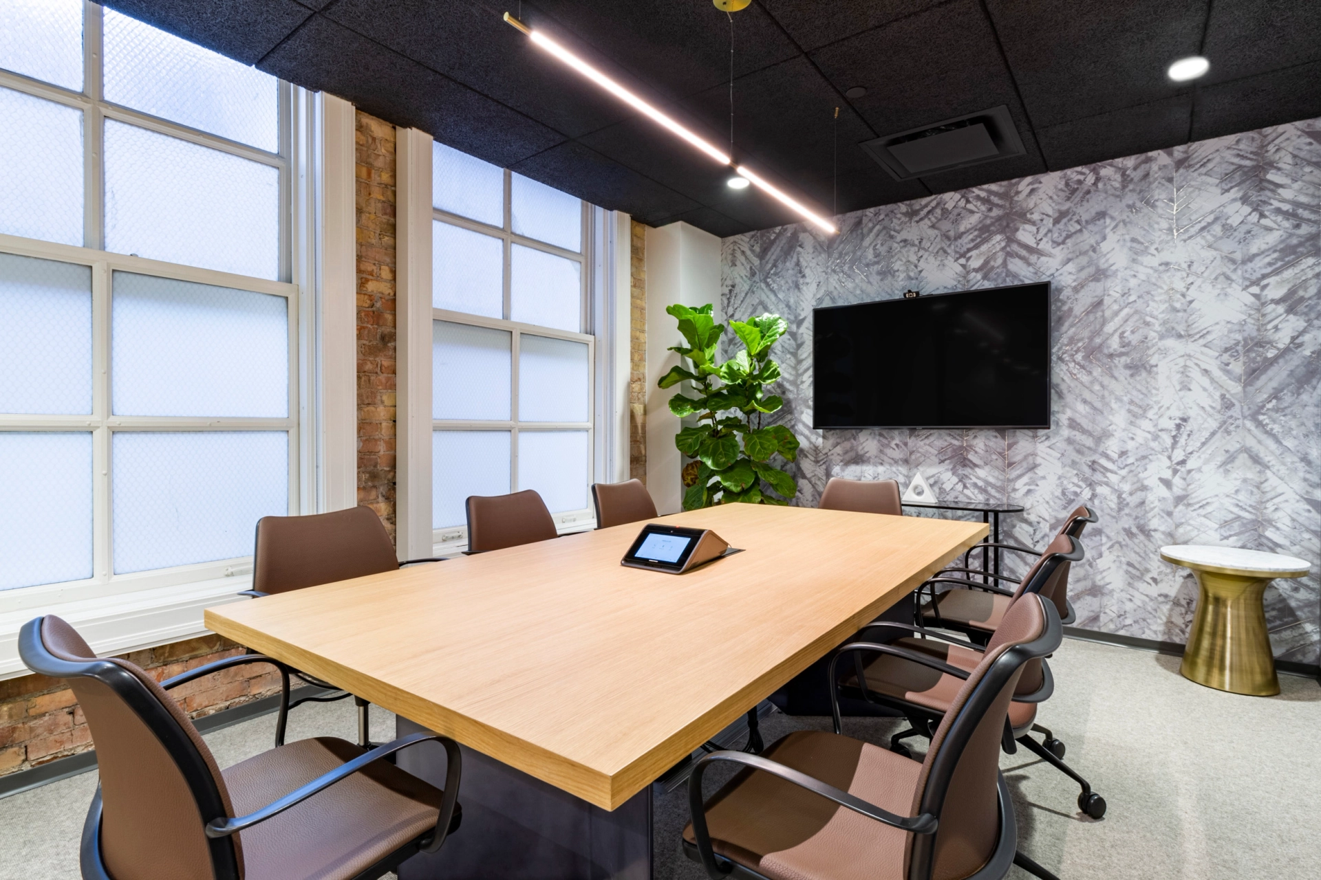 A coworking office in Salt Lake City equipped with a wooden table and chairs for conferences.