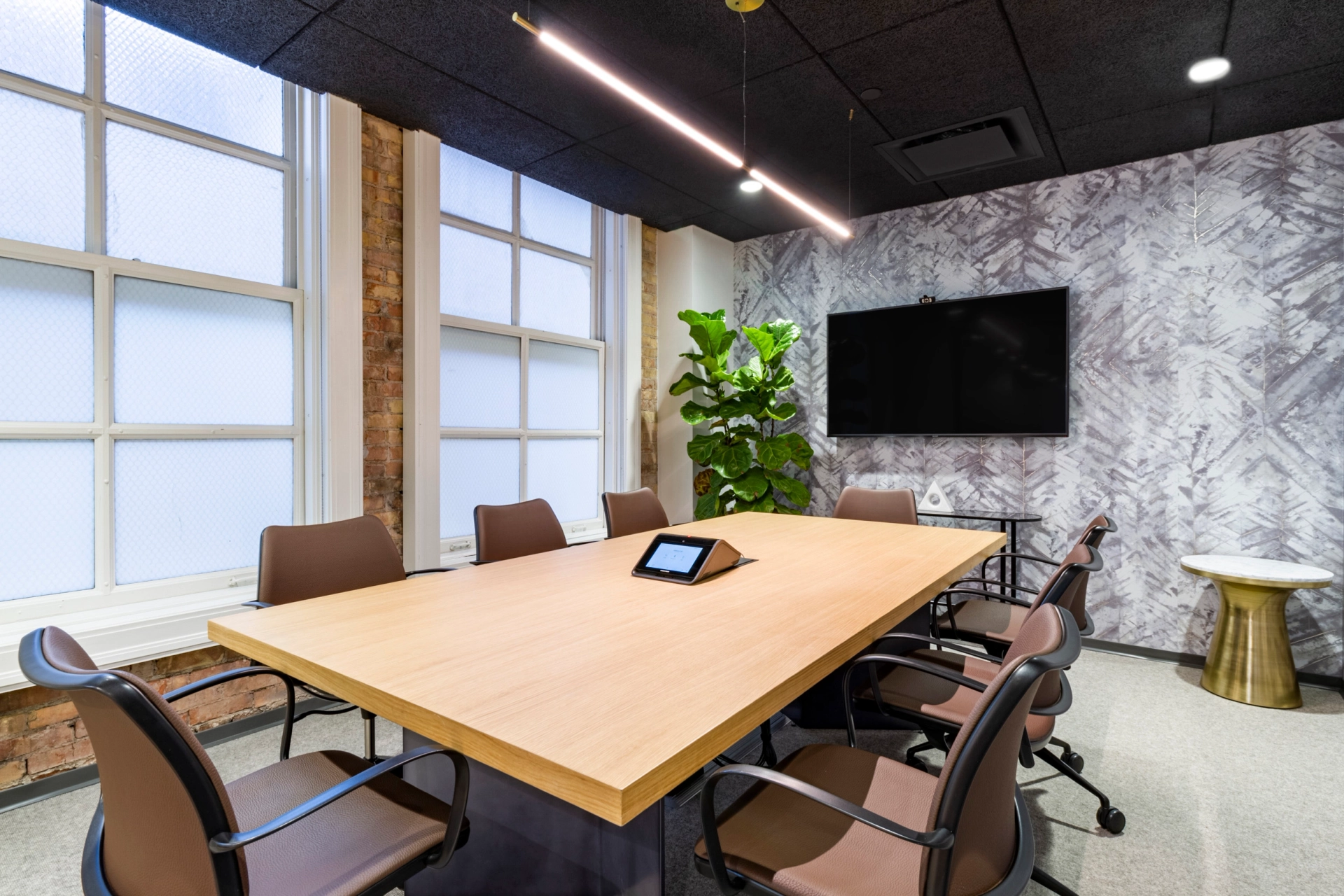 Une salle de réunion de coworking à Salt Lake City meublée d'une table et de chaises en bois.