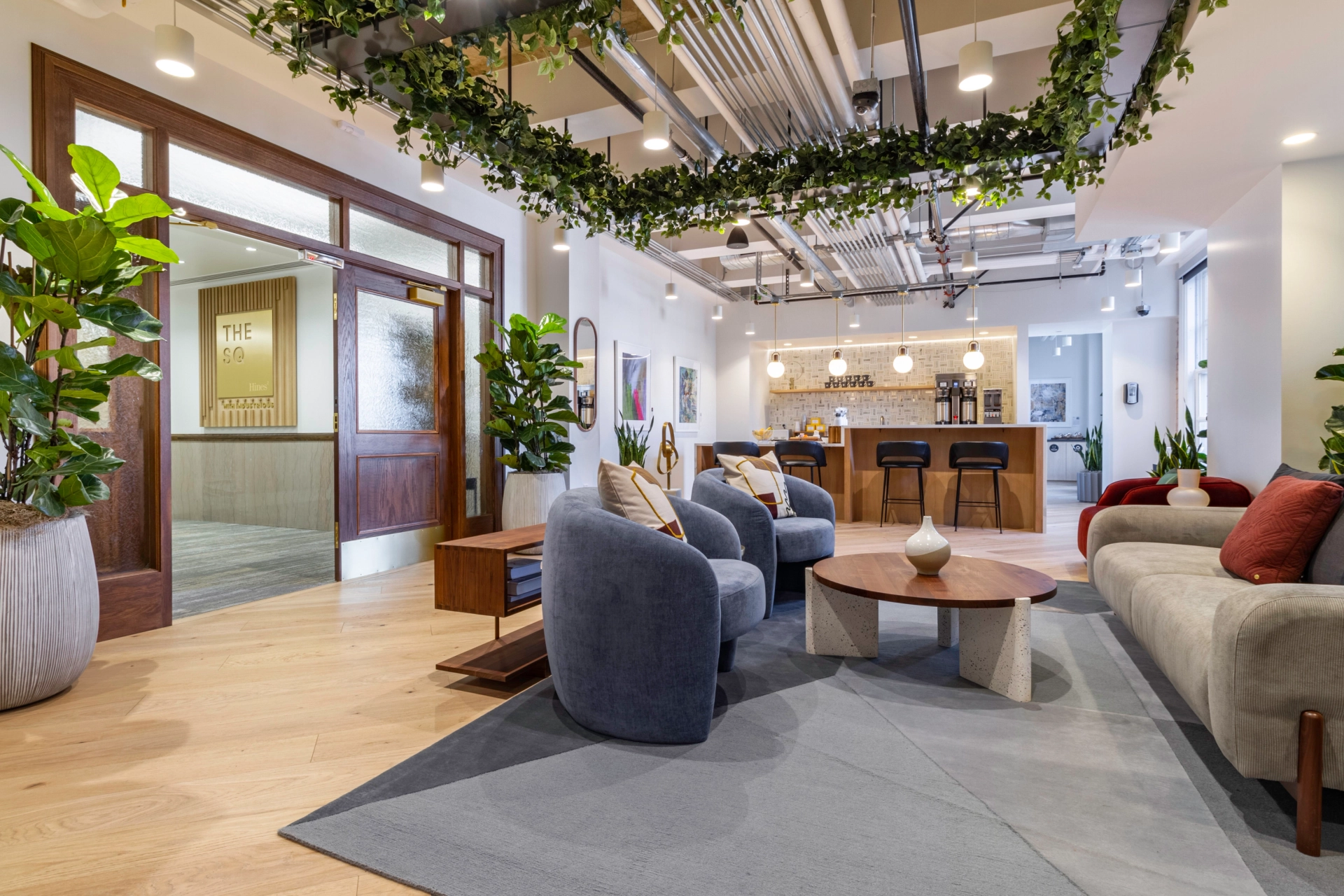 Une salle de réunion de coworking à Salt Lake City avec des canapés et des plantes suspendues au plafond.