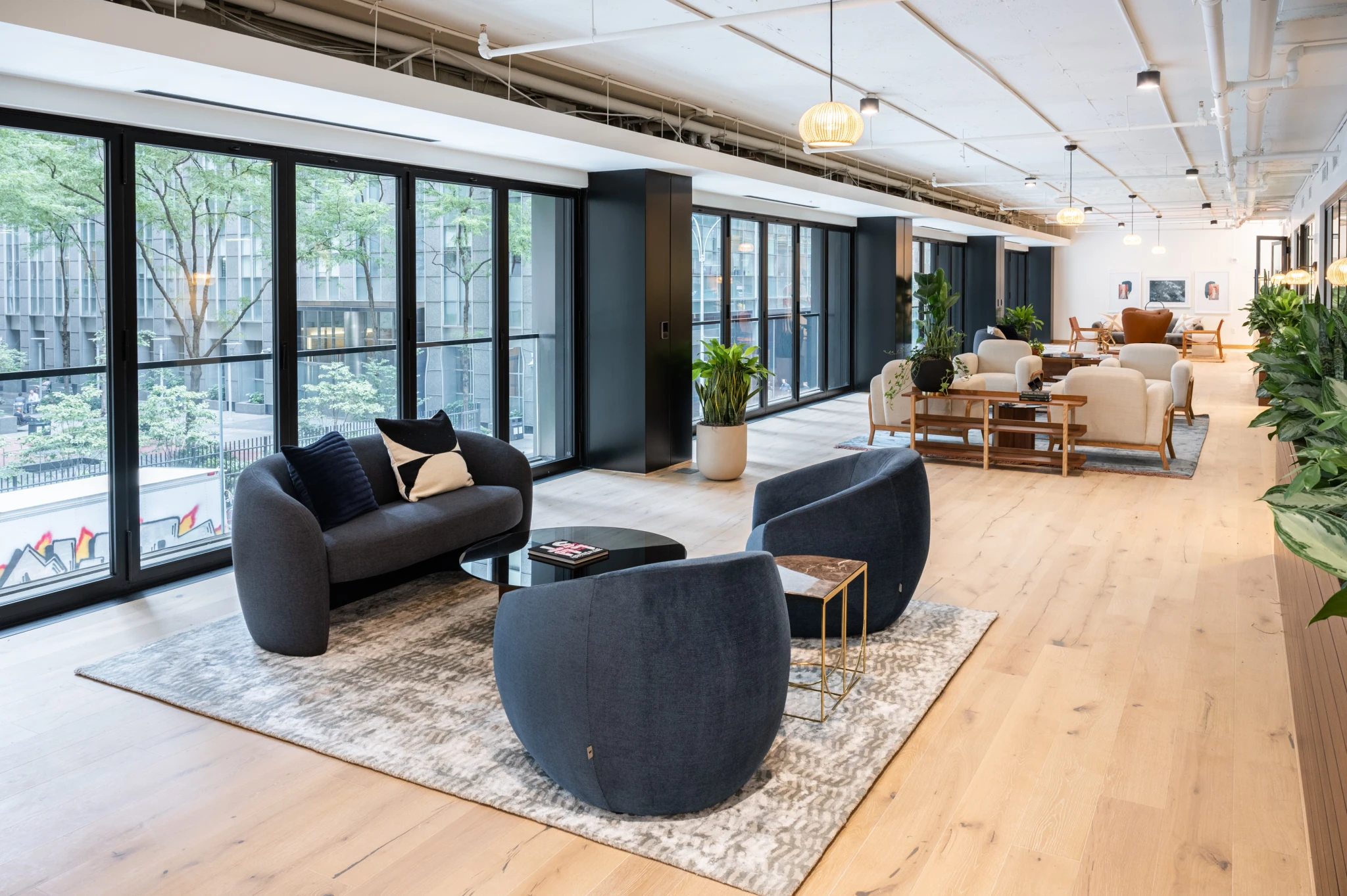 The lobby of a modern office building with large windows in New York, featuring a spacious workspace and meeting room.