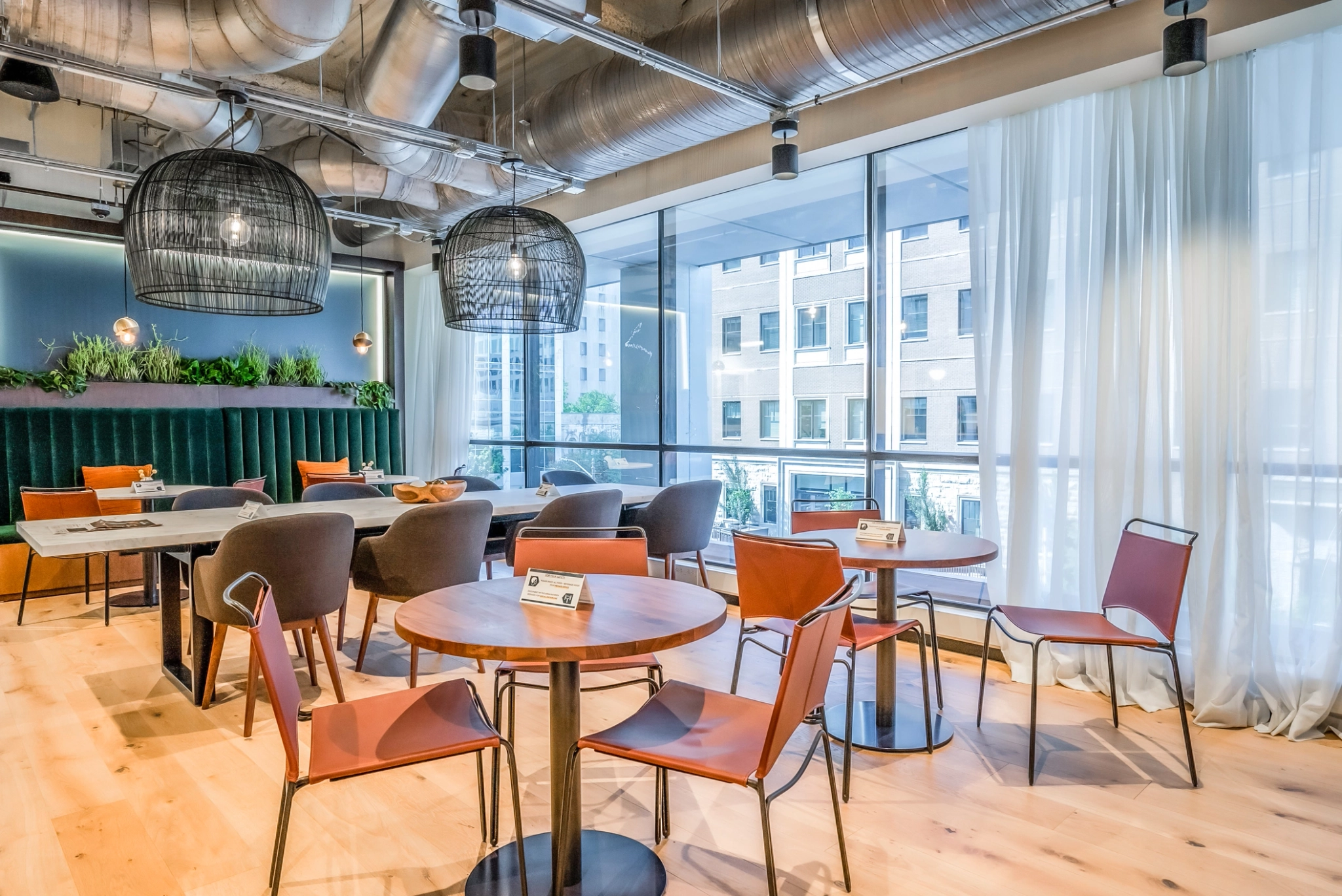 Un espace de coworking avec des tables et des chaises et une vue sur la ville.
