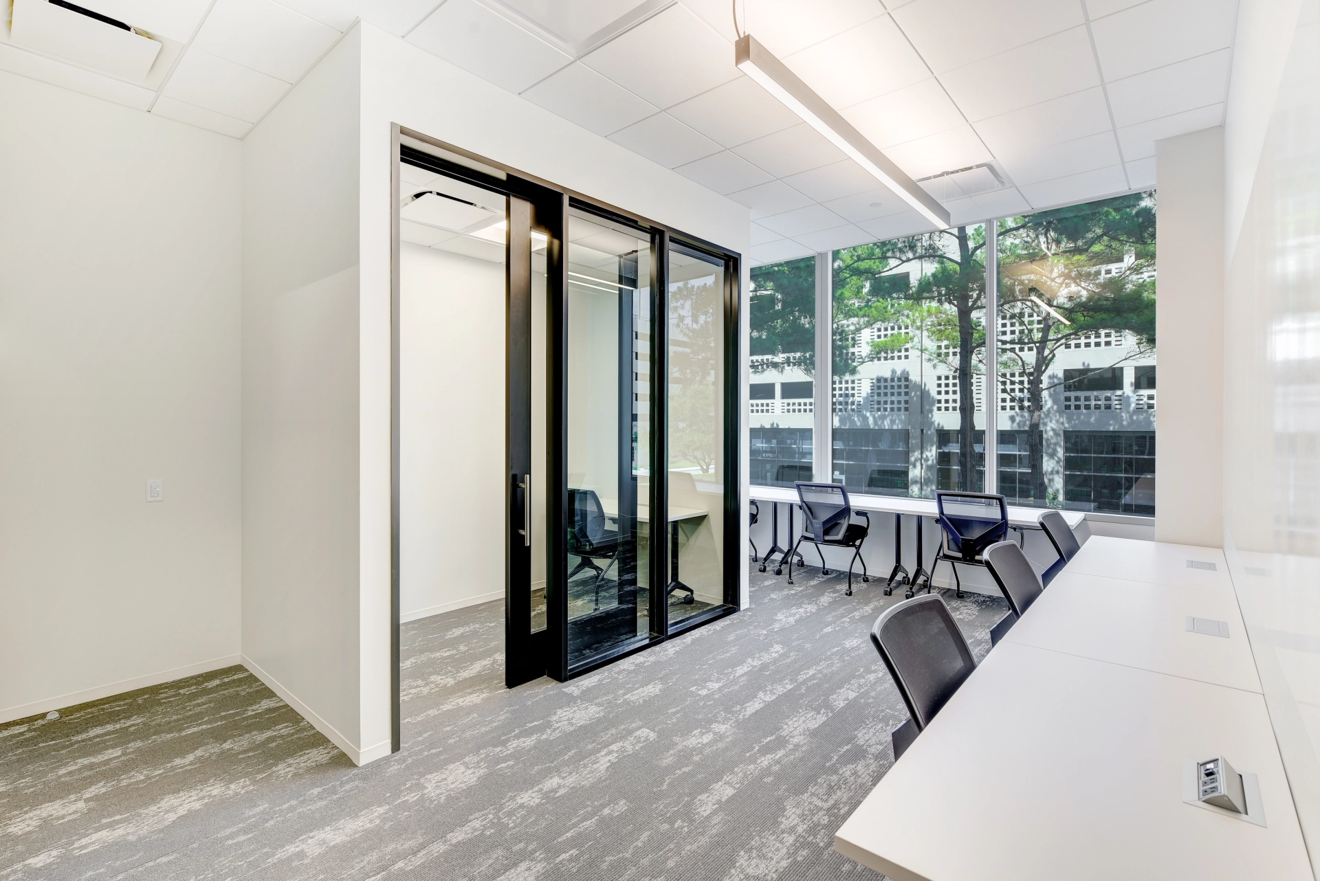 A coworking meeting room with a sliding glass door.