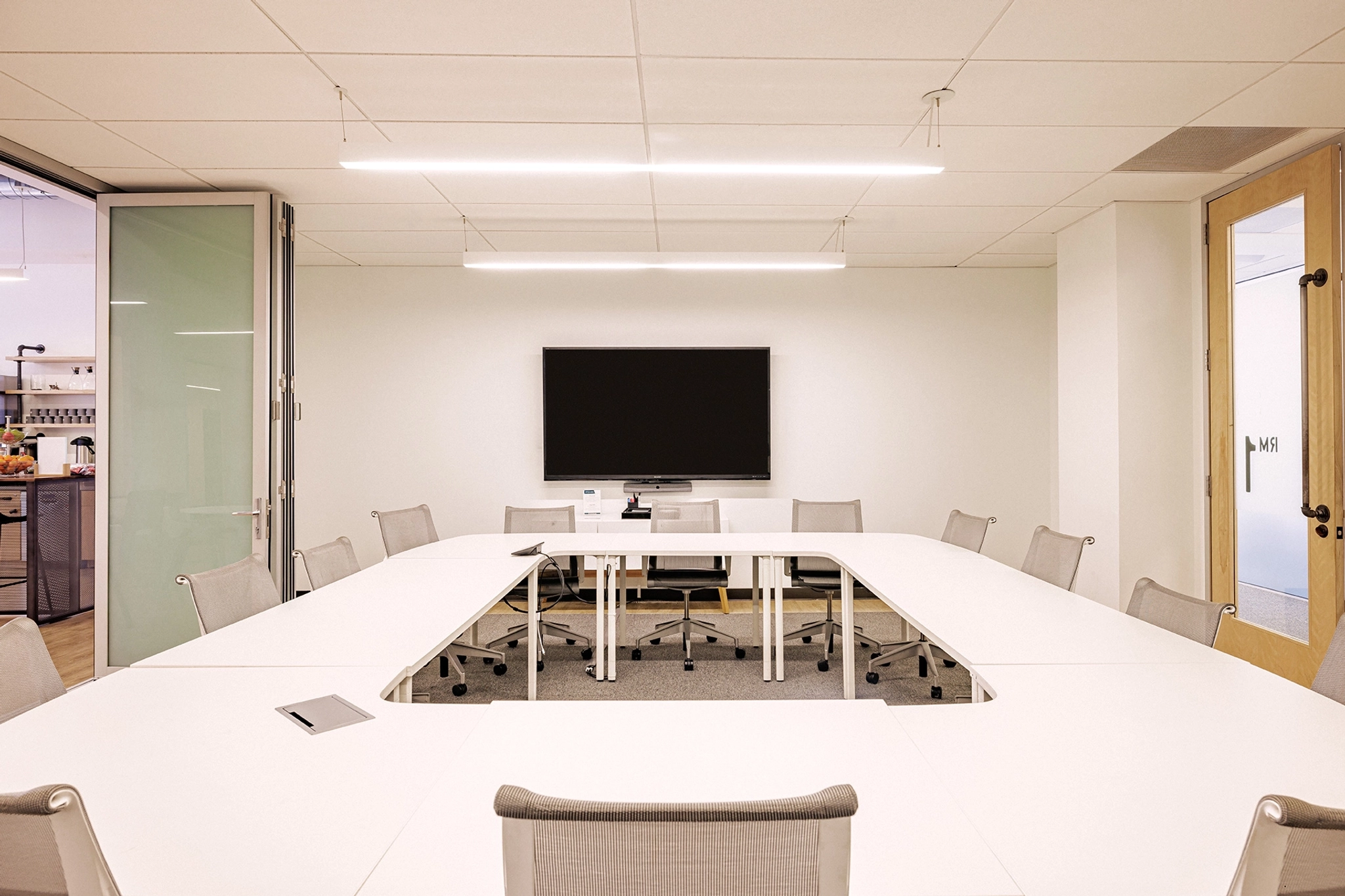un espace de coworking avec une table blanche et des chaises dans un bureau.