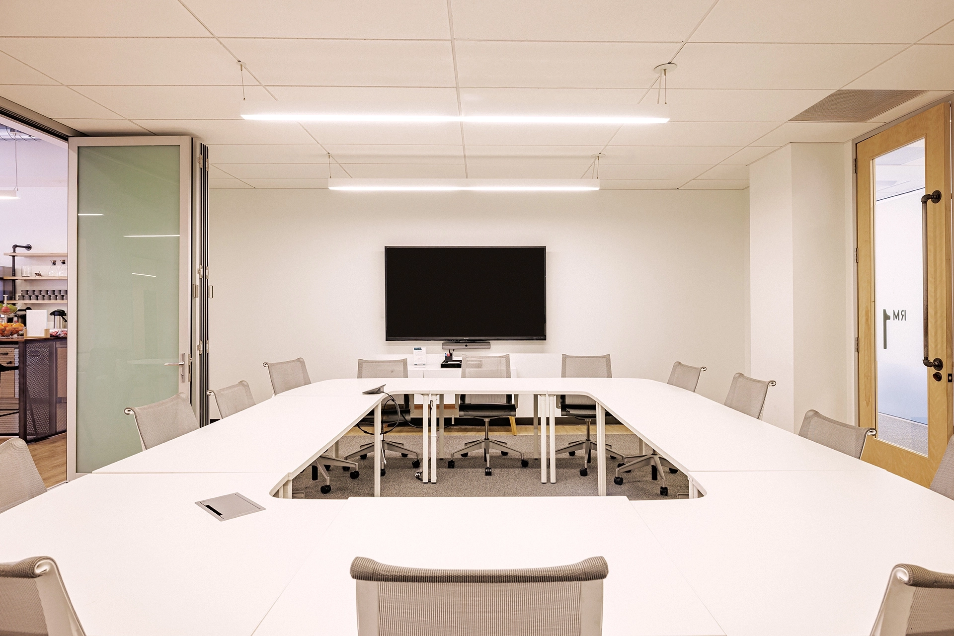 un espace de coworking avec une table blanche et des chaises dans un bureau.
