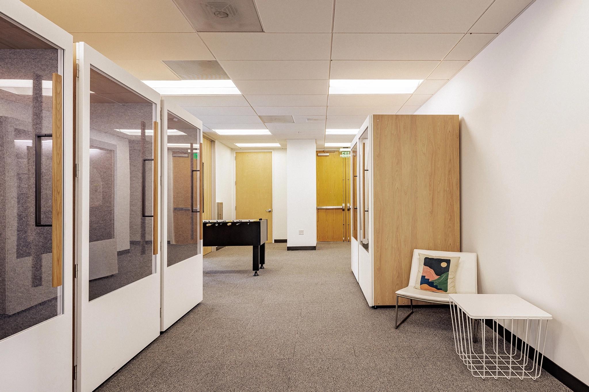 A coworking workspace with a table and chairs in the middle of the room.