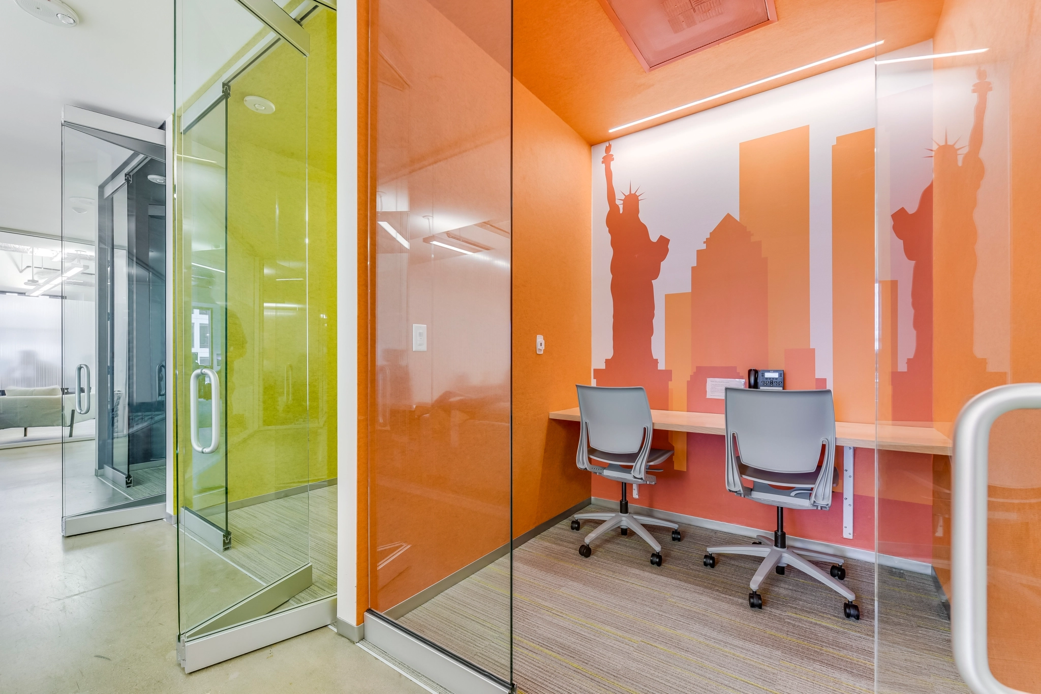 A brightly colored coworking office with a glass wall.