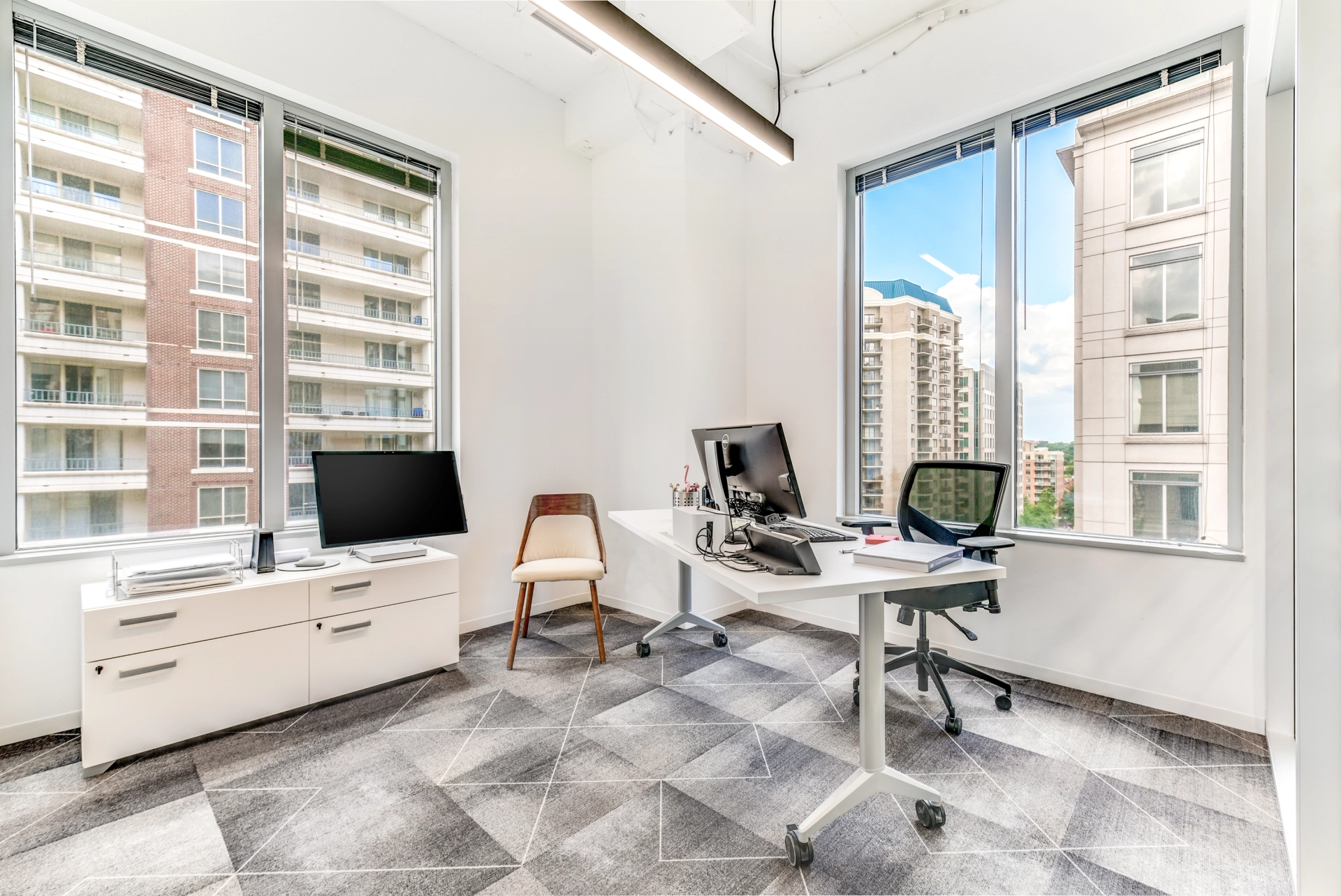 Espace de coworking Arlington avec de grandes fenêtres et un bureau, parfait comme salle de réunion.