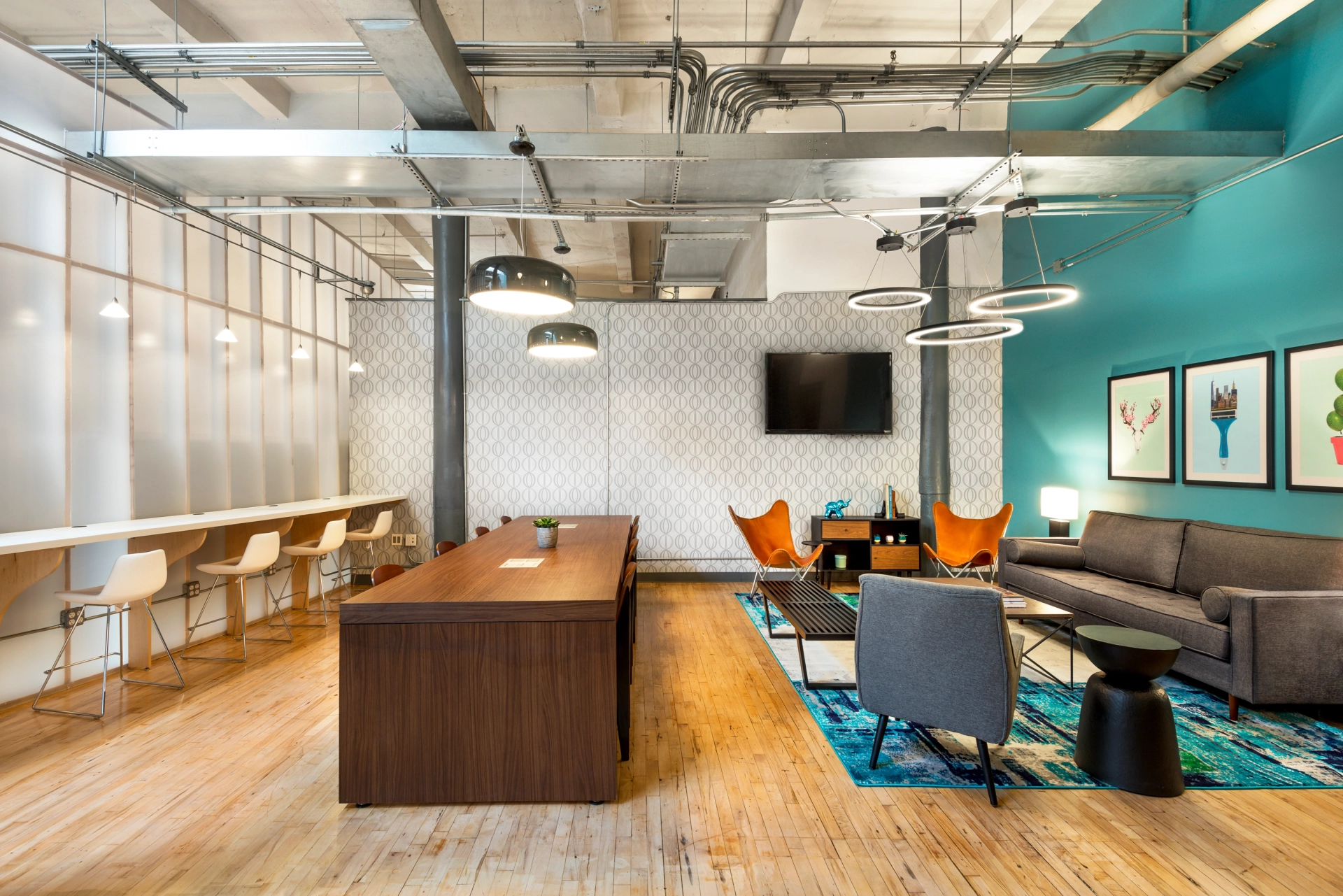 Un espace de coworking avec un bureau moderne aux murs bleus et au parquet.