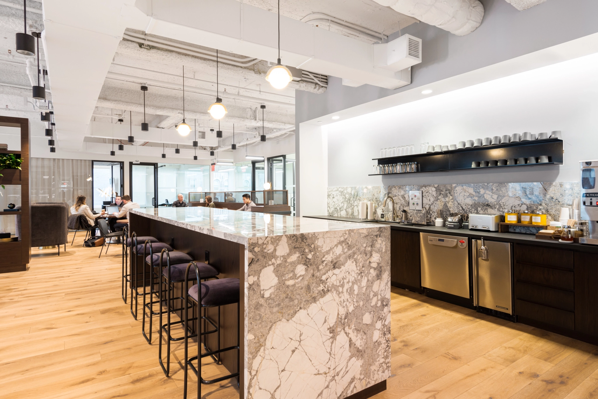 A coworking office with a marble counter for meetings and bar stools.