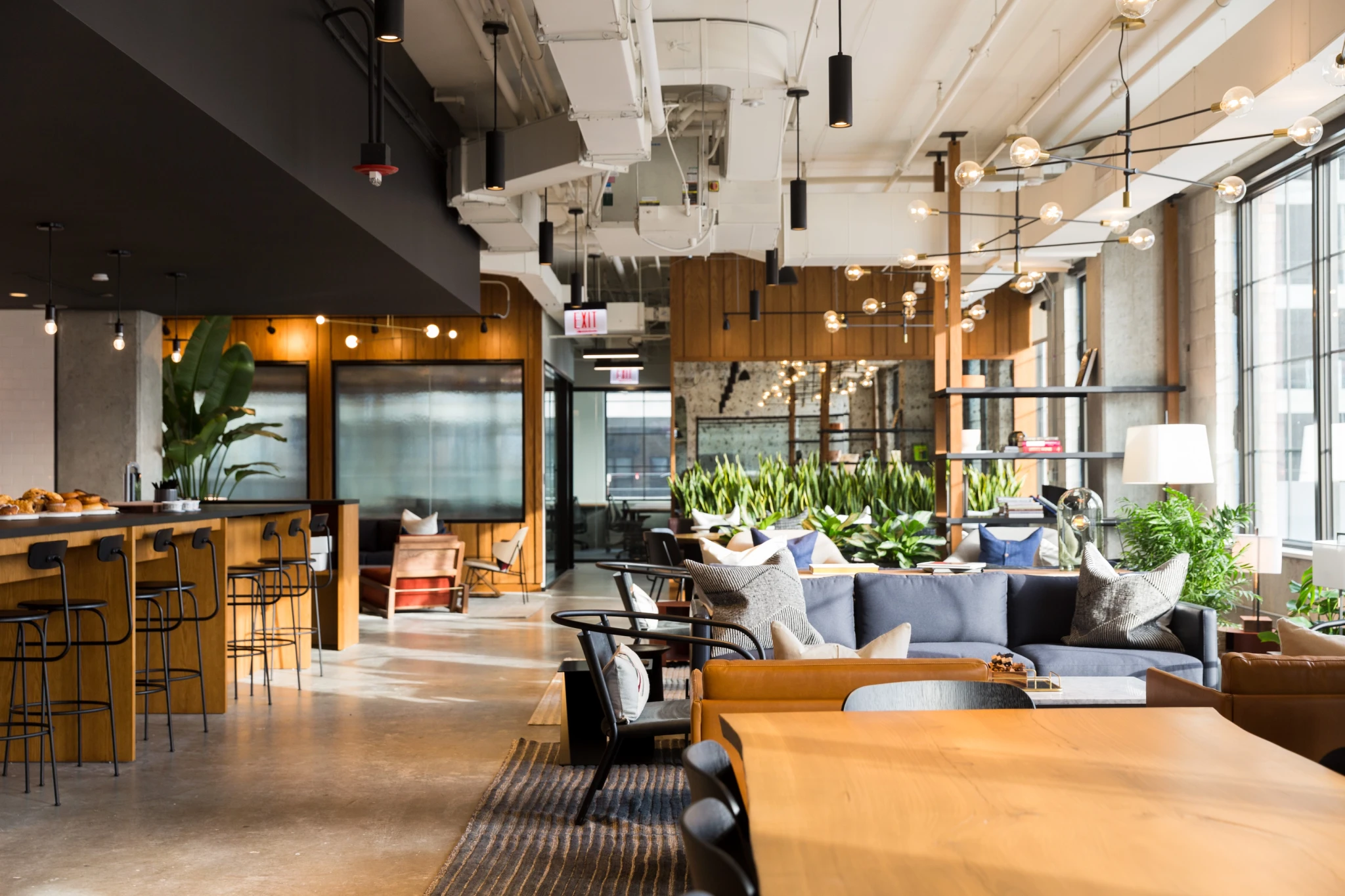 A modern office building lobby designed as a versatile workspace with meeting rooms for coworking.