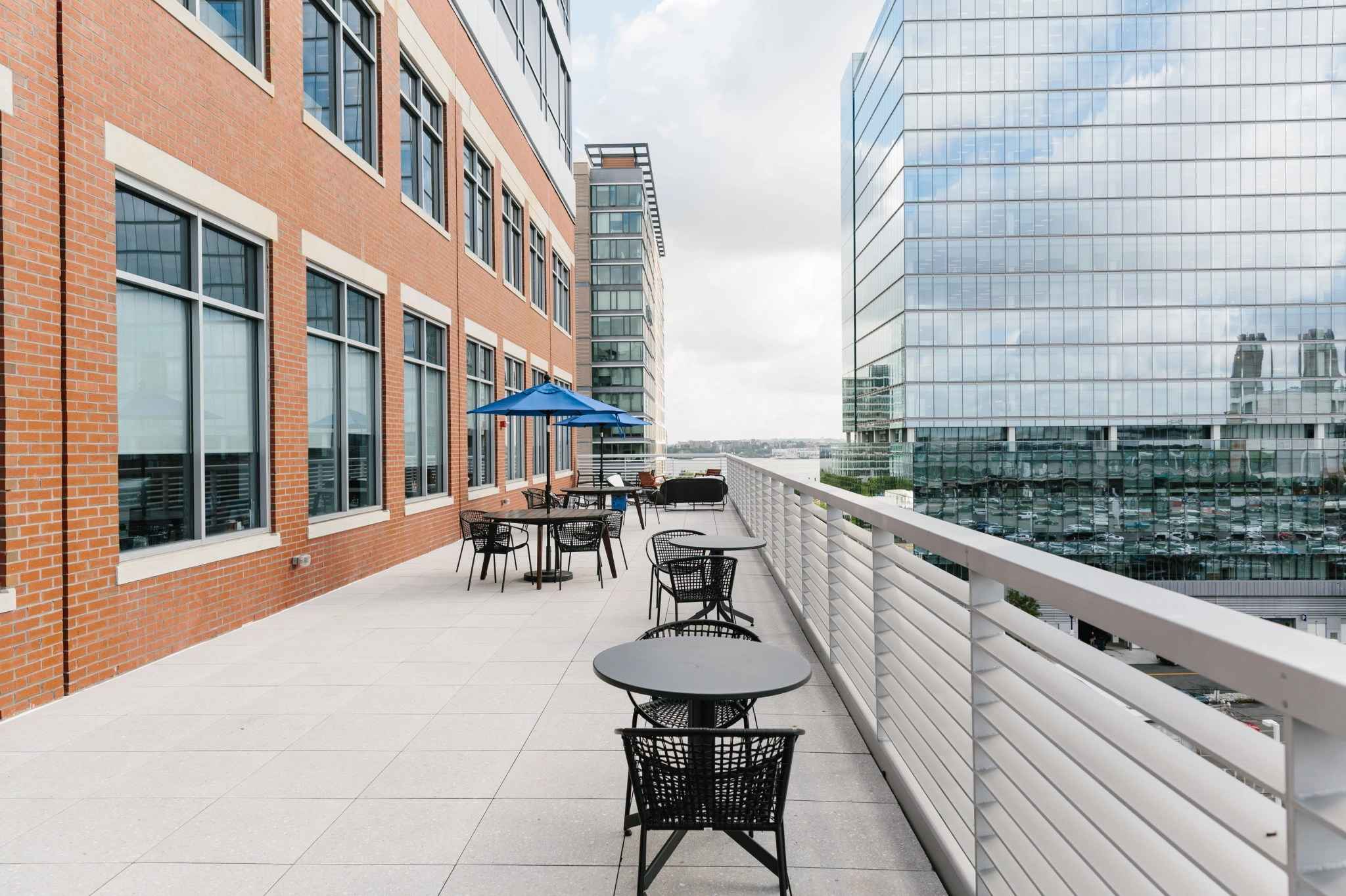 An outdoor workspace in Boston with tables and chairs, providing a meeting room atmosphere and a panoramic view of the city.