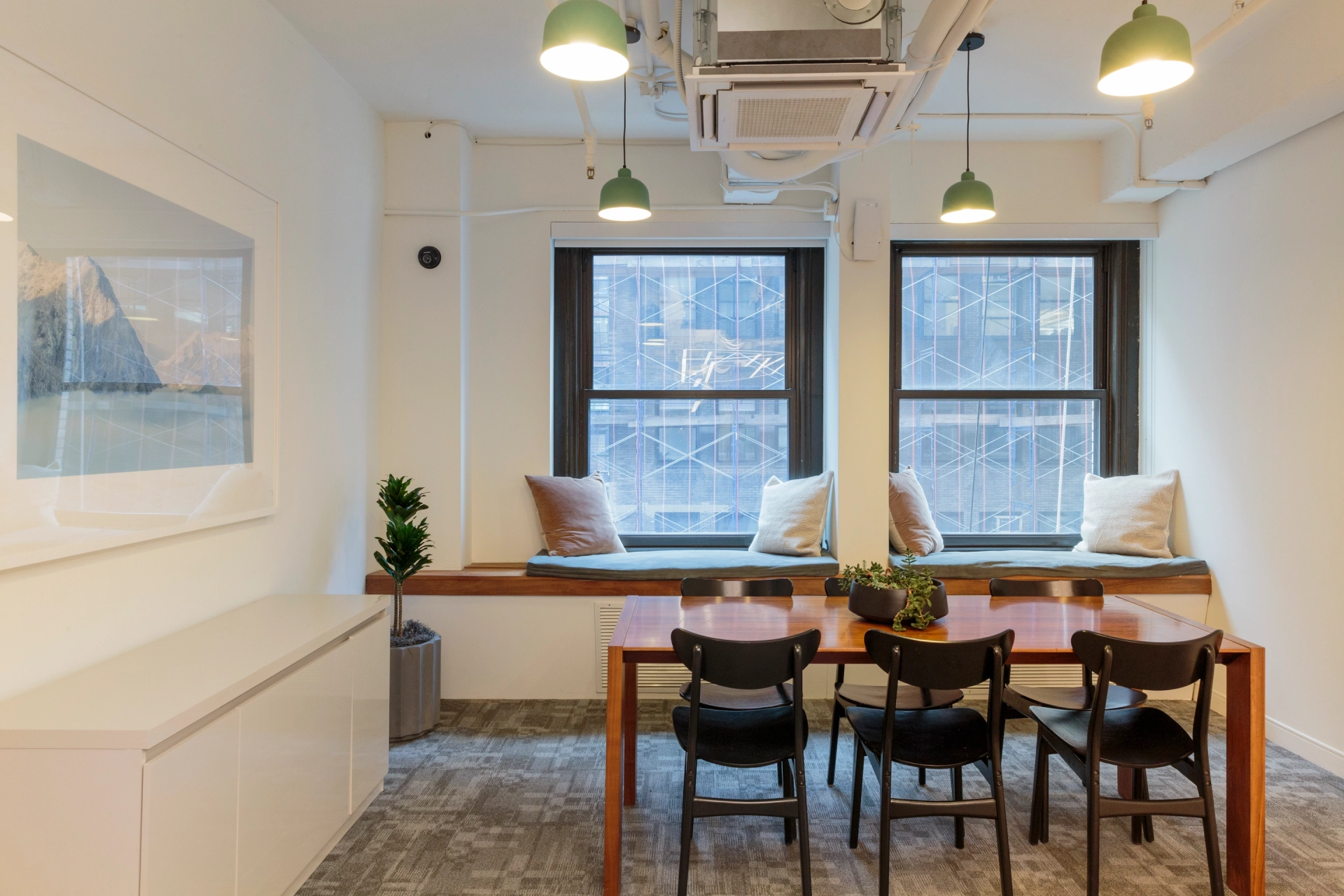 A Manhattan office workspace with a table and chairs.