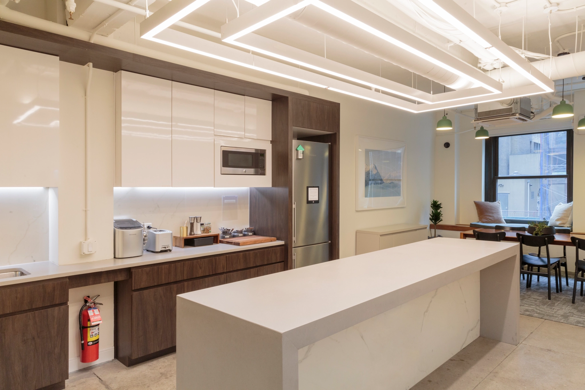 A coworking kitchen in an office with white cabinets and counter tops.