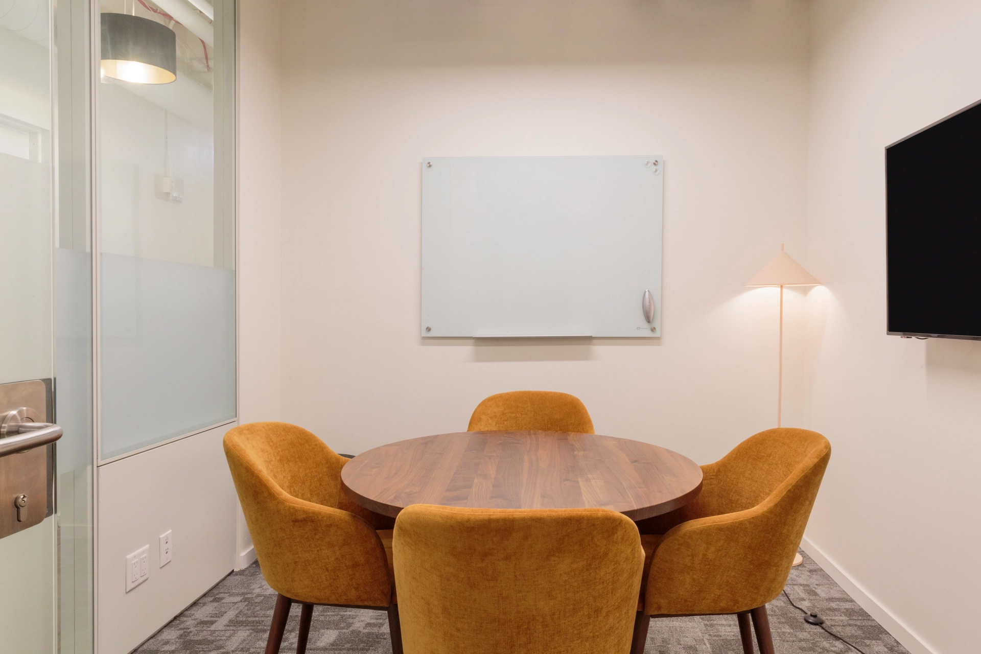 A Manhattan office meeting room equipped with a table, chairs, and a TV.