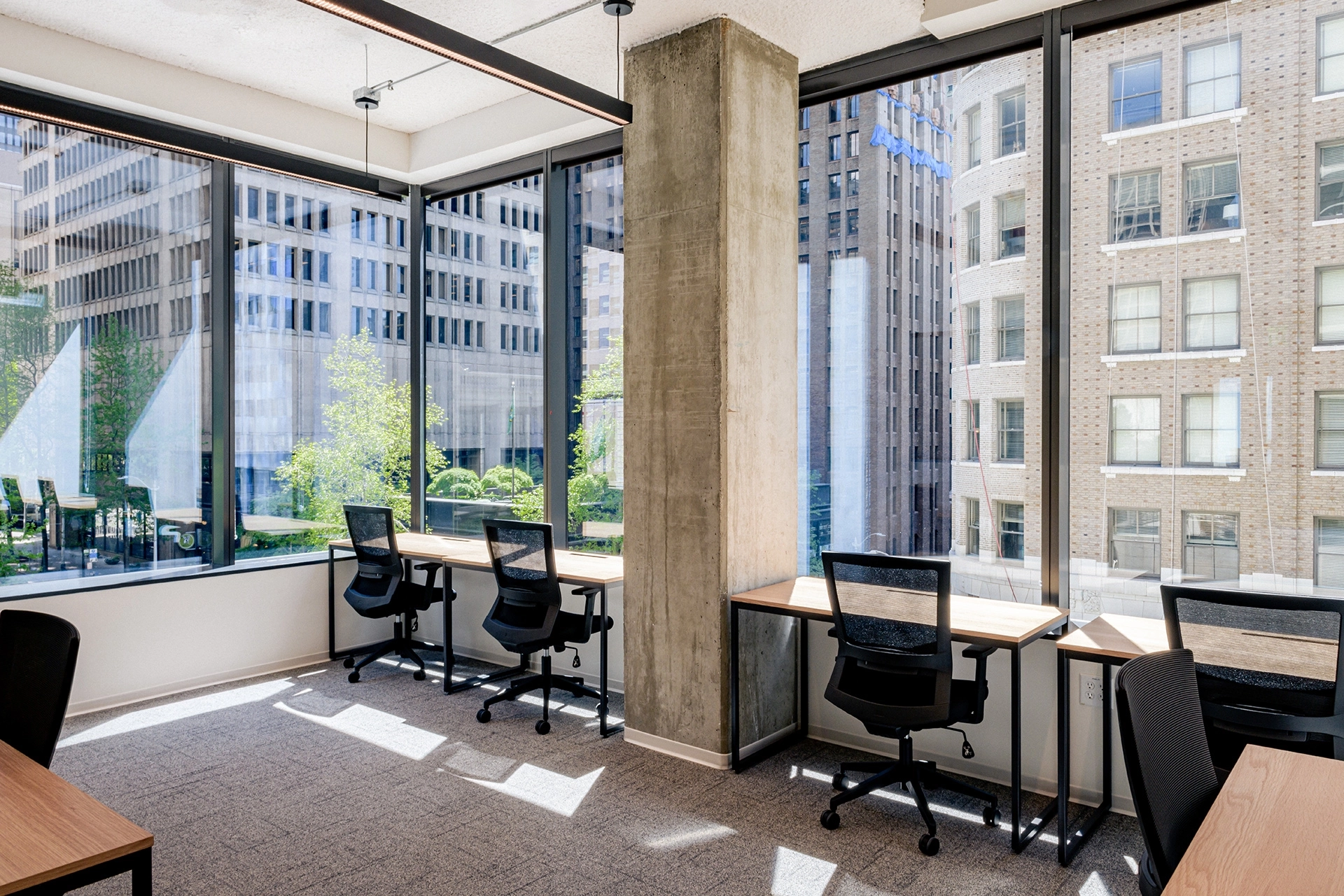 An open workspace with large windows overlooking a city.