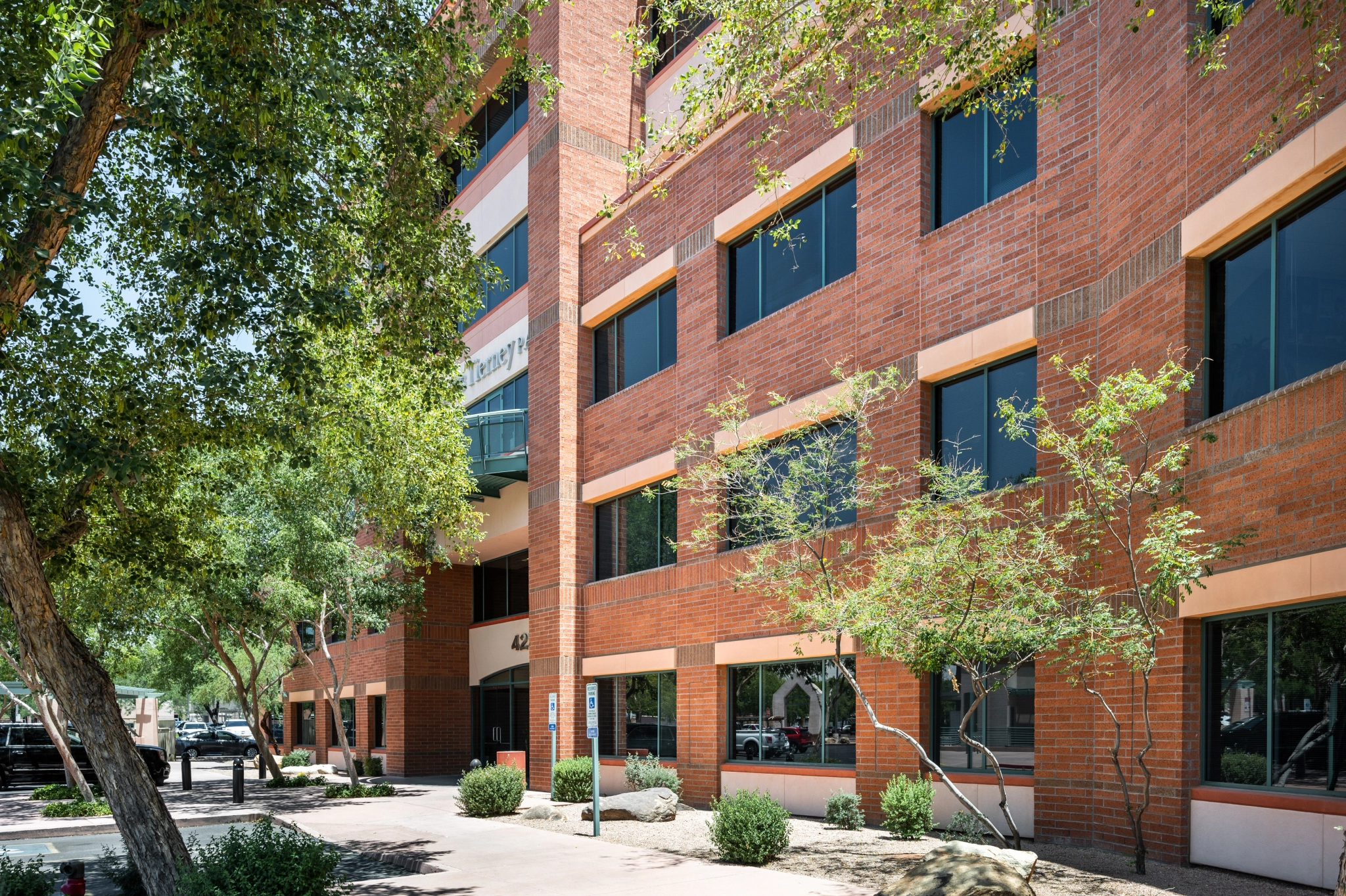 A red brick building with trees in front of it, providing Scottsdale workspace and meeting rooms.