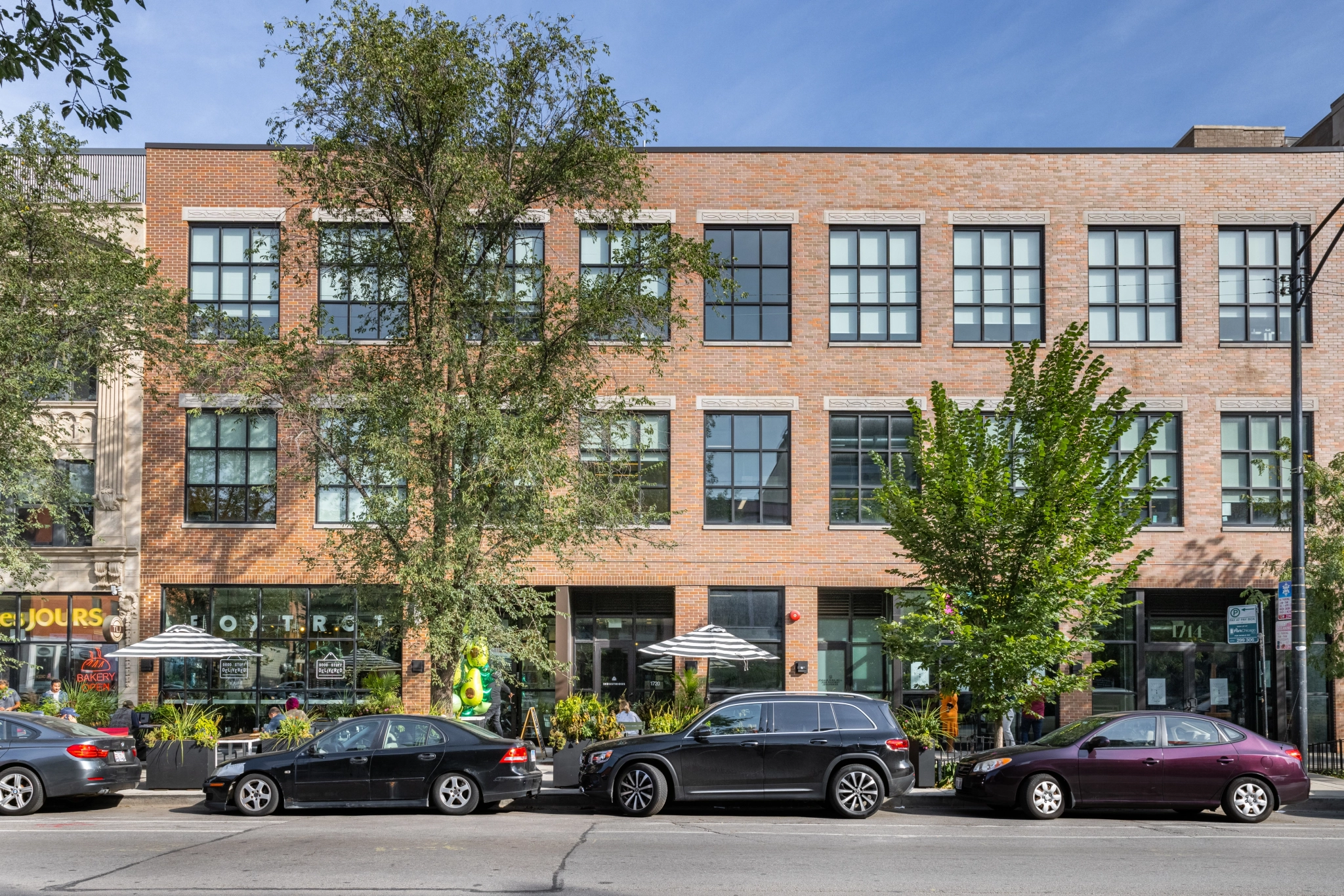 A Chicago building with cars parked in front of it that serves as a workspace and has meeting rooms available.