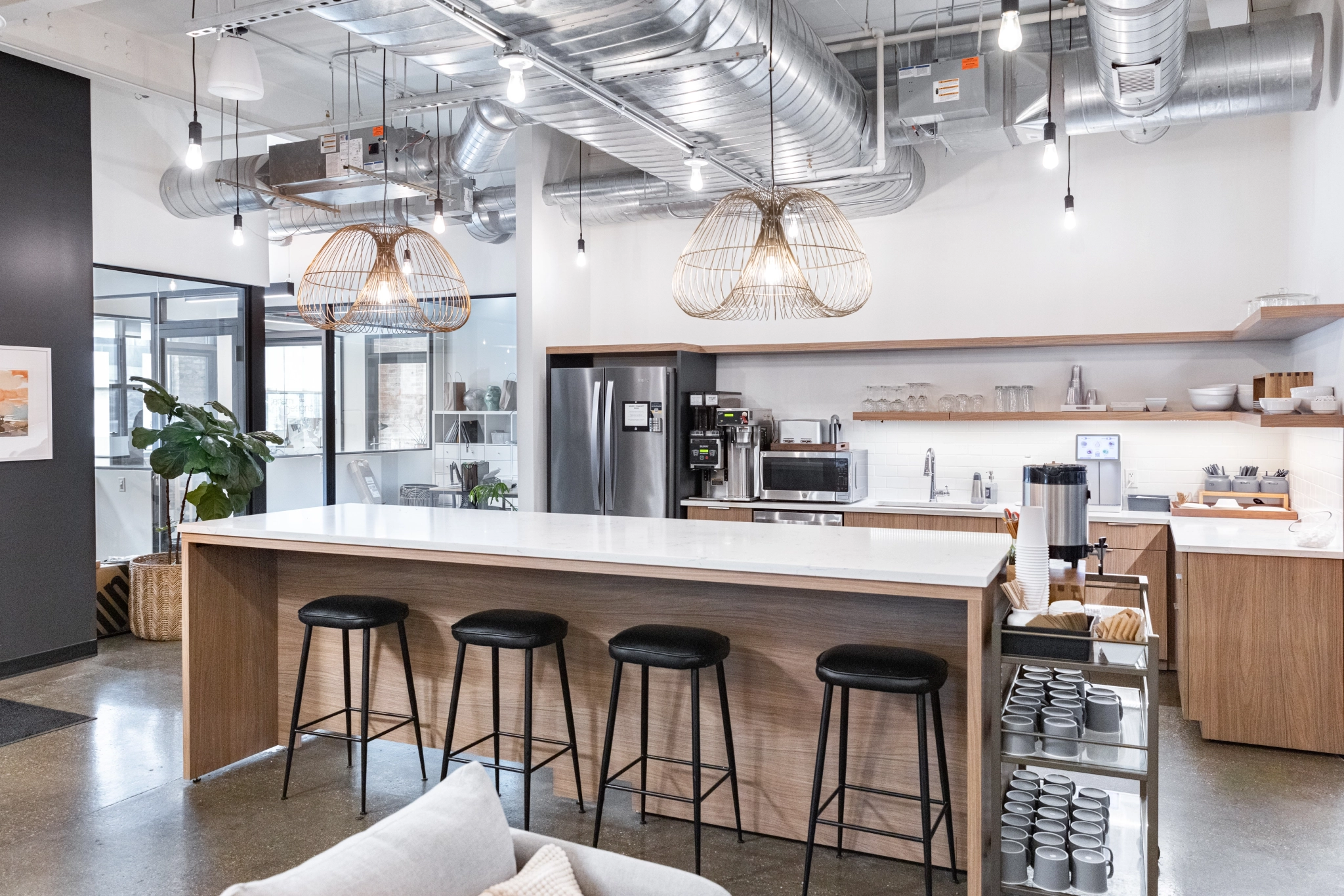 A modern coworking space in Chicago with a kitchen and bar stools.