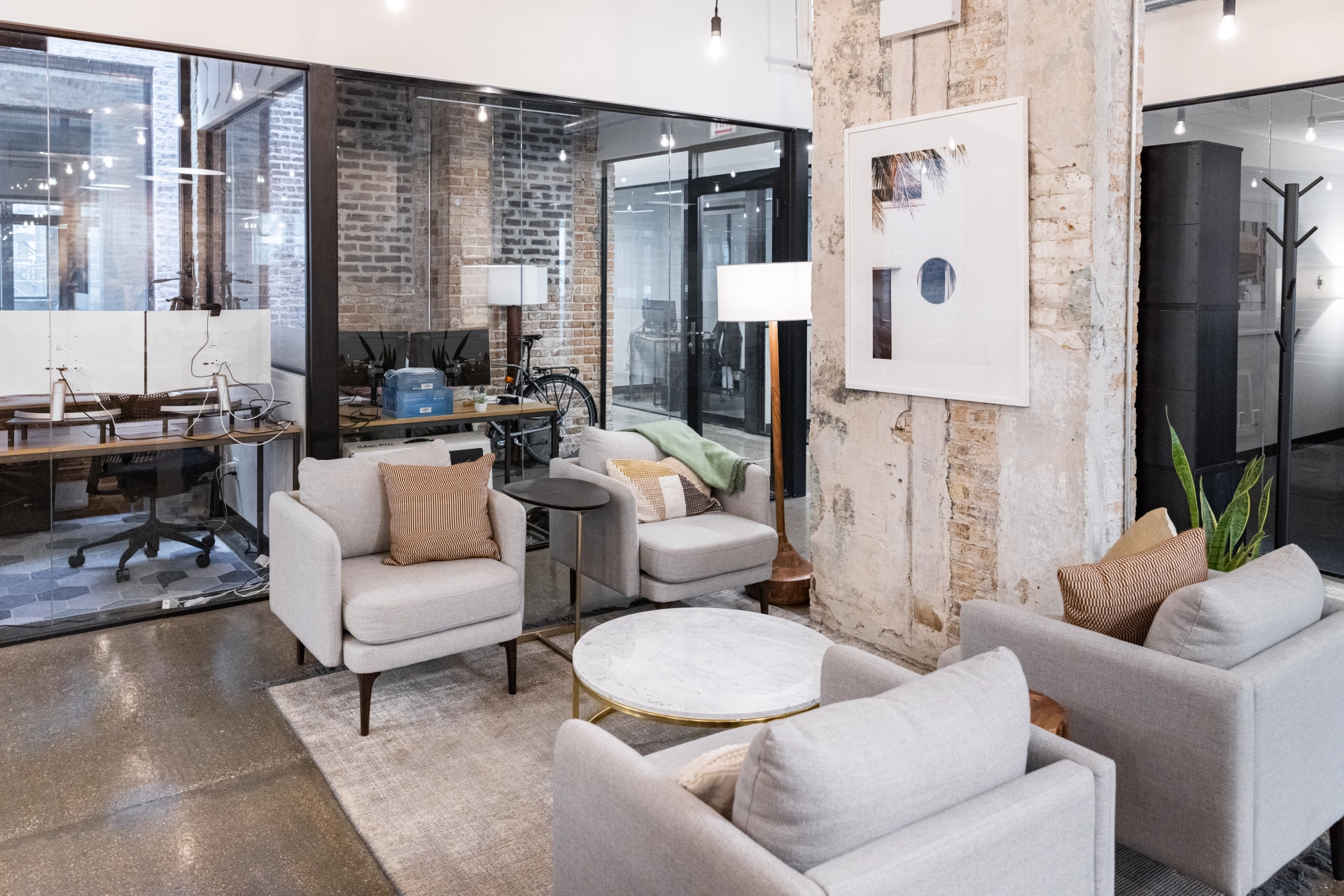 A modern office with coworking amenities, including couches, chairs, and a coffee table.