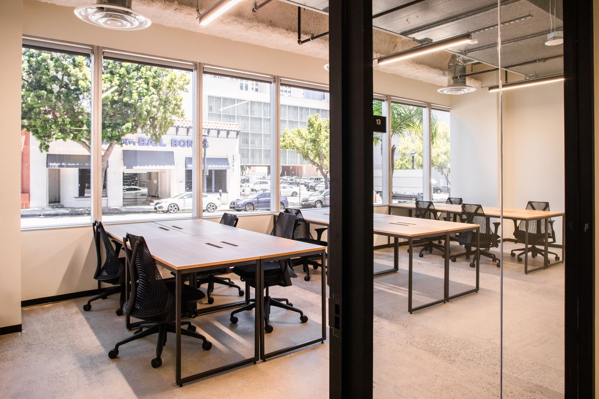 A coworking space or office with a desk, chairs, and a glass door.