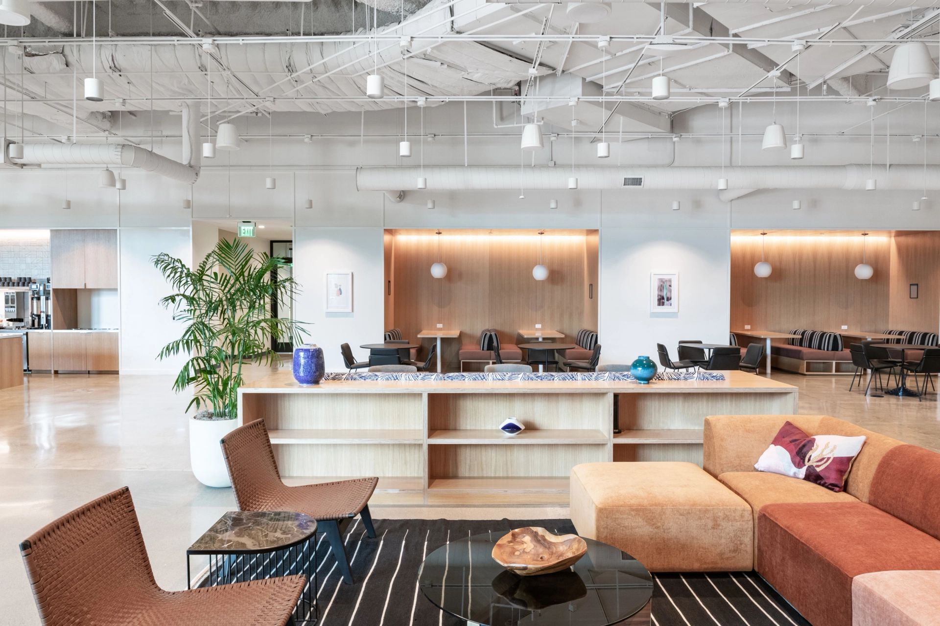 Un espace de coworking à Newport Beach avec un grand espace bureau ouvert avec des canapés et une table basse.