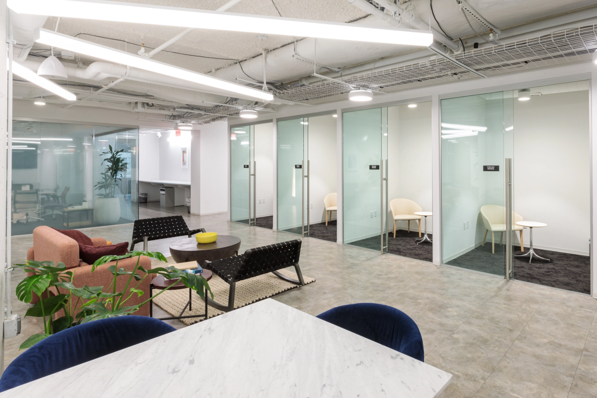 Arlington office with glass wall for meetings and workspace with chairs.